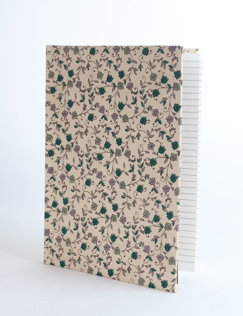 Beige A5 hard cover notebook with green and gray floral vine pattern, shown partially open with lined pages visible