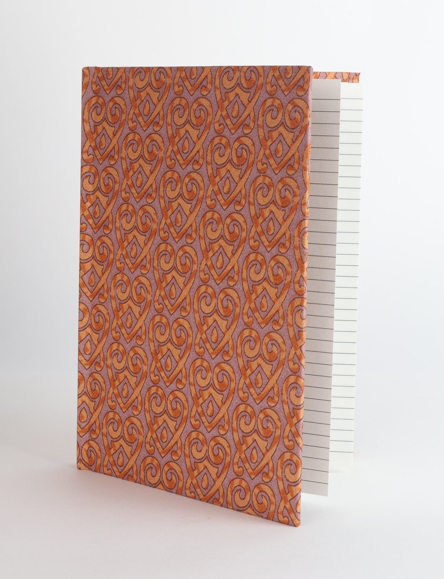 A5 hard cover notebook with green fabric cover featuring brown floral pattern, shown standing open with grid pages visible