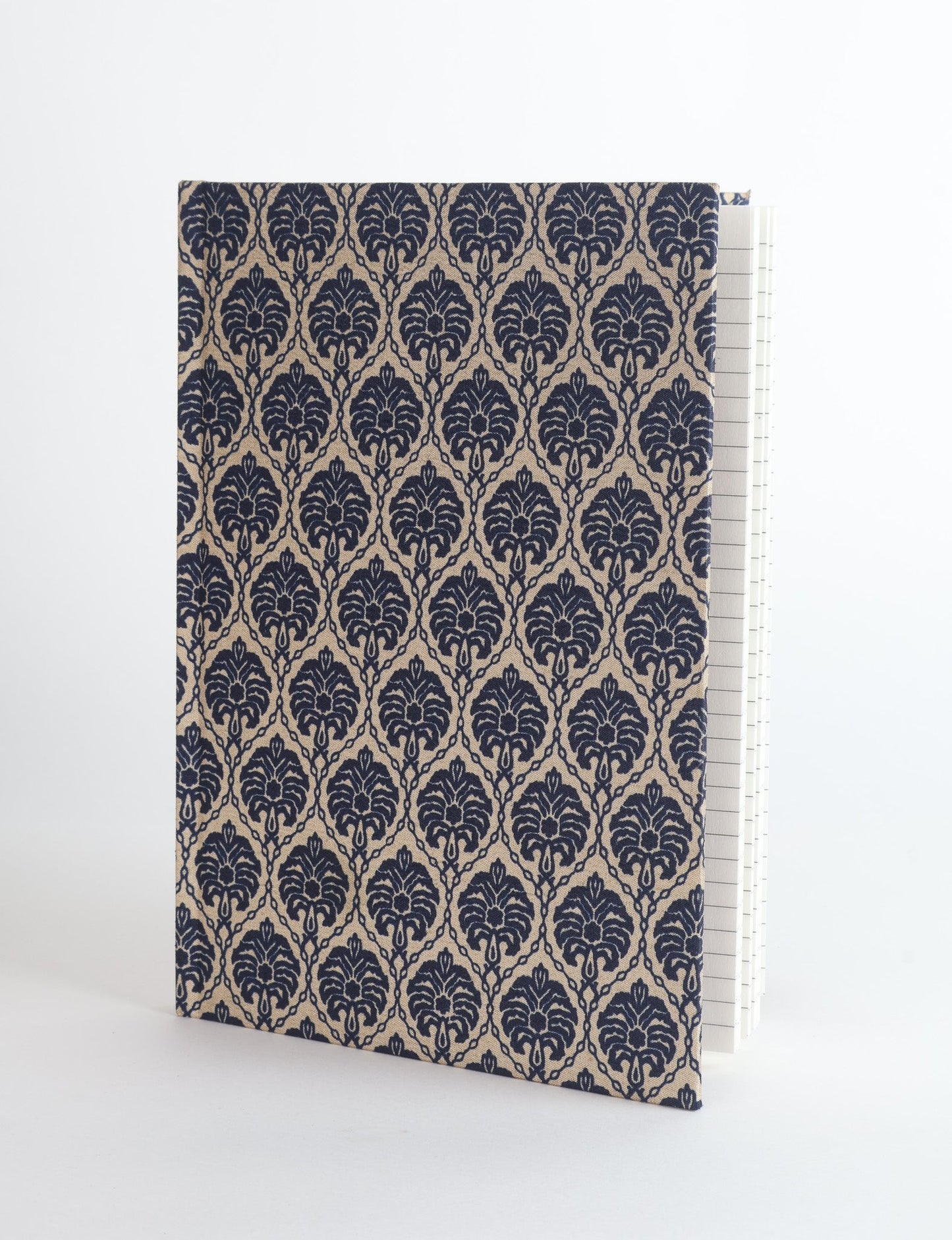 A5 hard cover notebook with green fabric cover featuring brown floral pattern, shown standing open with grid pages visible