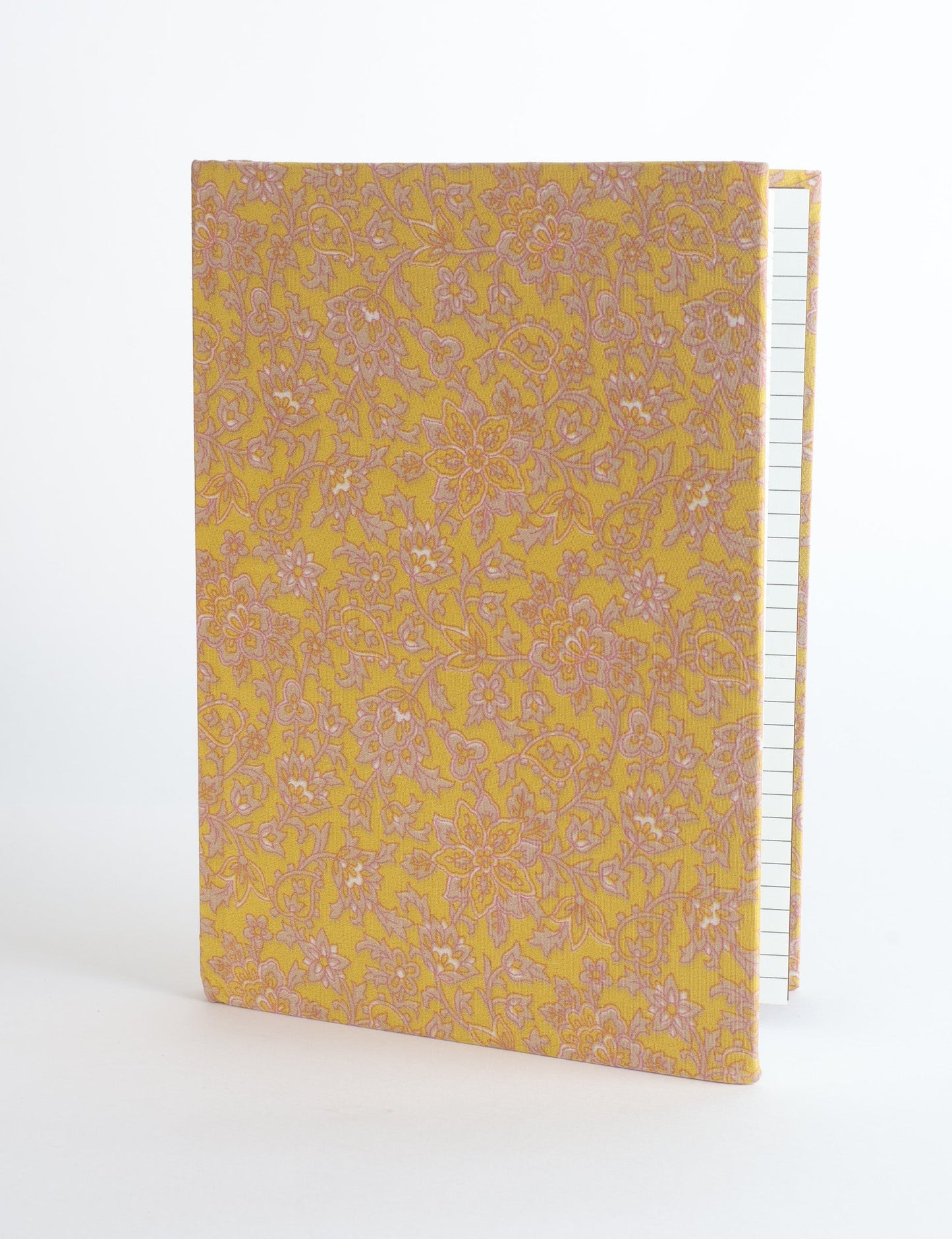 A5 hard cover notebook with green fabric cover featuring brown floral pattern, shown standing open with grid pages visible
