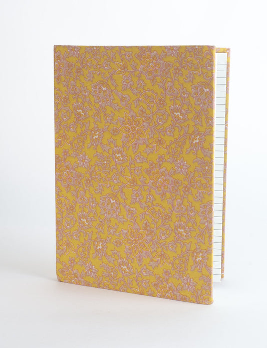 A5 hard cover notebook with green fabric cover featuring brown floral pattern, shown standing open with grid pages visible