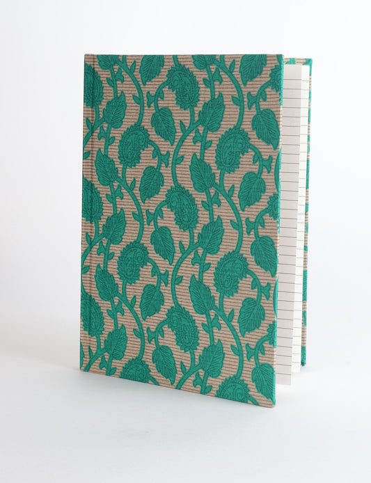 A5 hard cover notebook with green fabric cover featuring brown floral pattern, shown standing open with grid pages visible