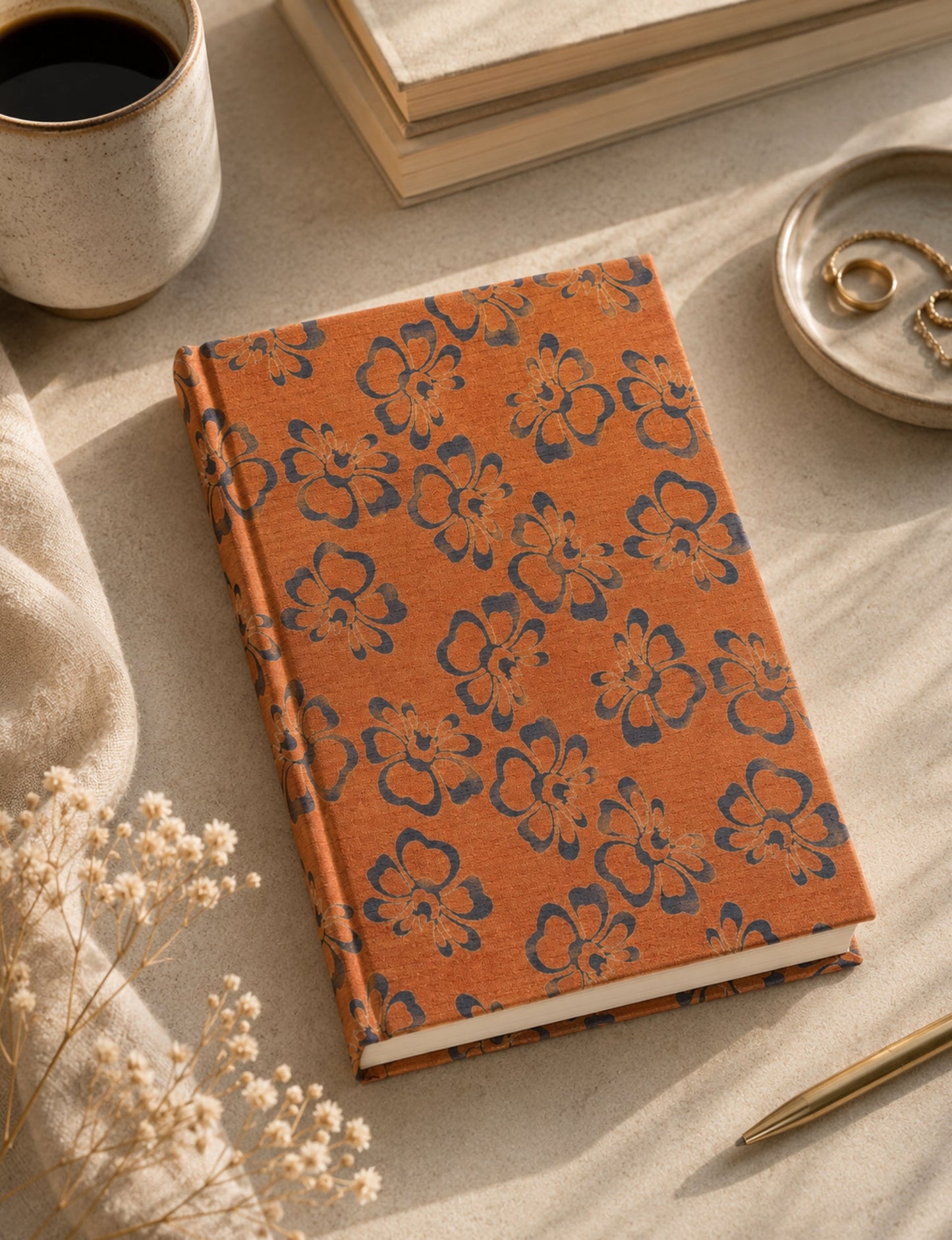 A5 hard cover notebook with green cover and beige floral pattern, shown closed on a wooden surface