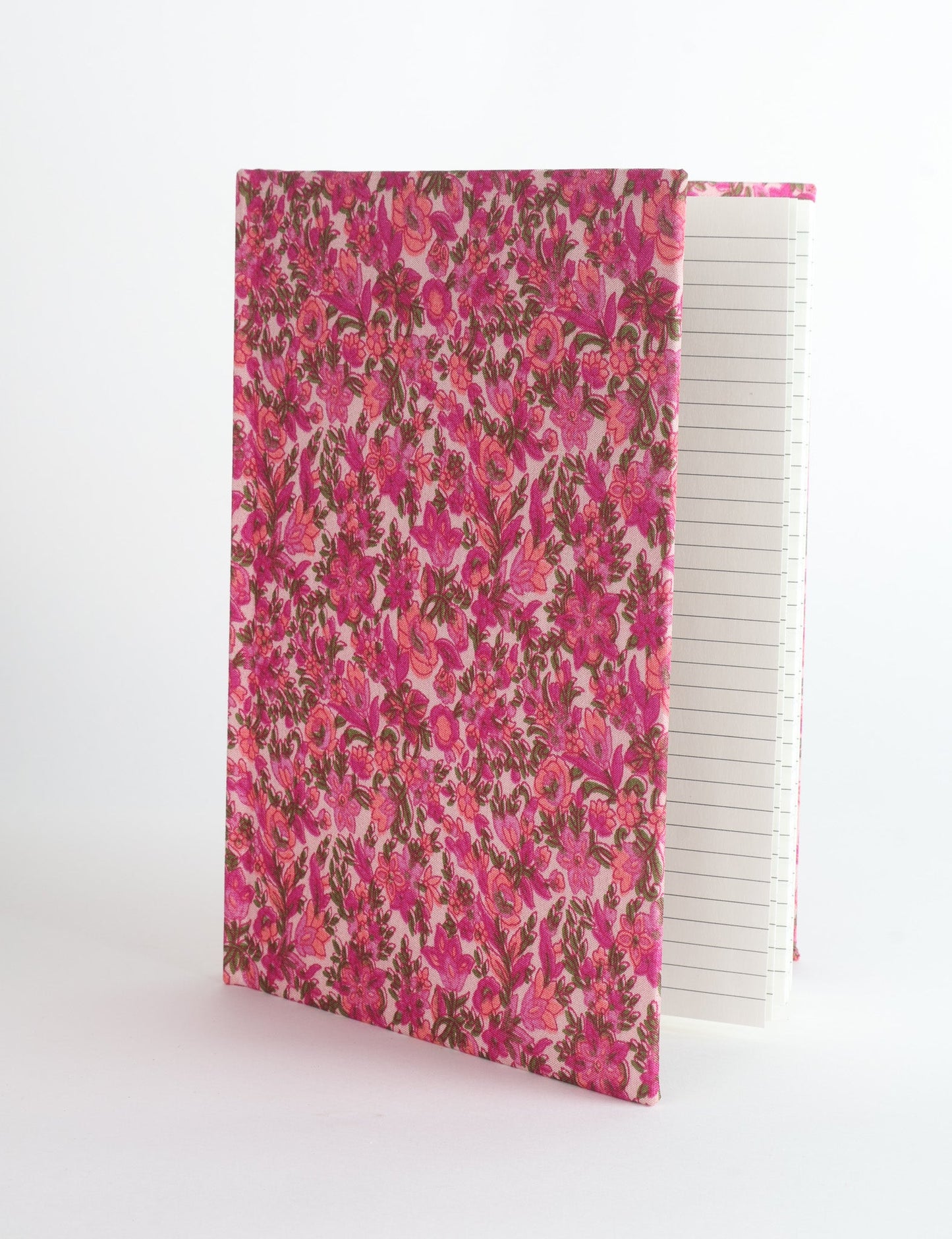 A5 hard cover notebook with green fabric cover featuring brown floral pattern, shown standing open with grid pages visible