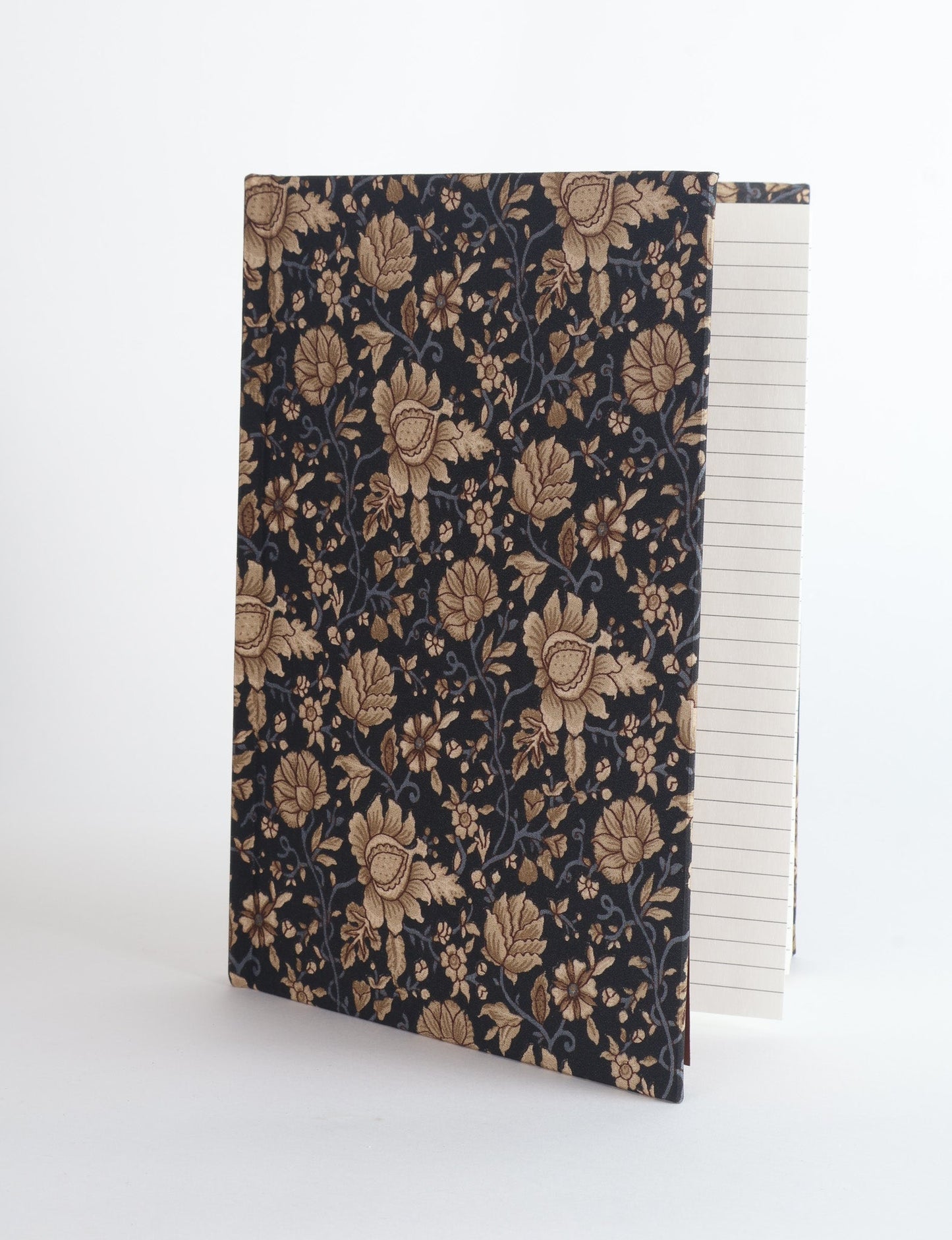 A5 hard cover notebook with green fabric cover featuring brown floral pattern, shown standing open with grid pages visible