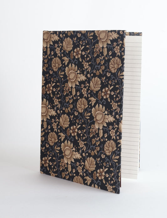 A5 hard cover notebook with green fabric cover featuring brown floral pattern, shown standing open with grid pages visible