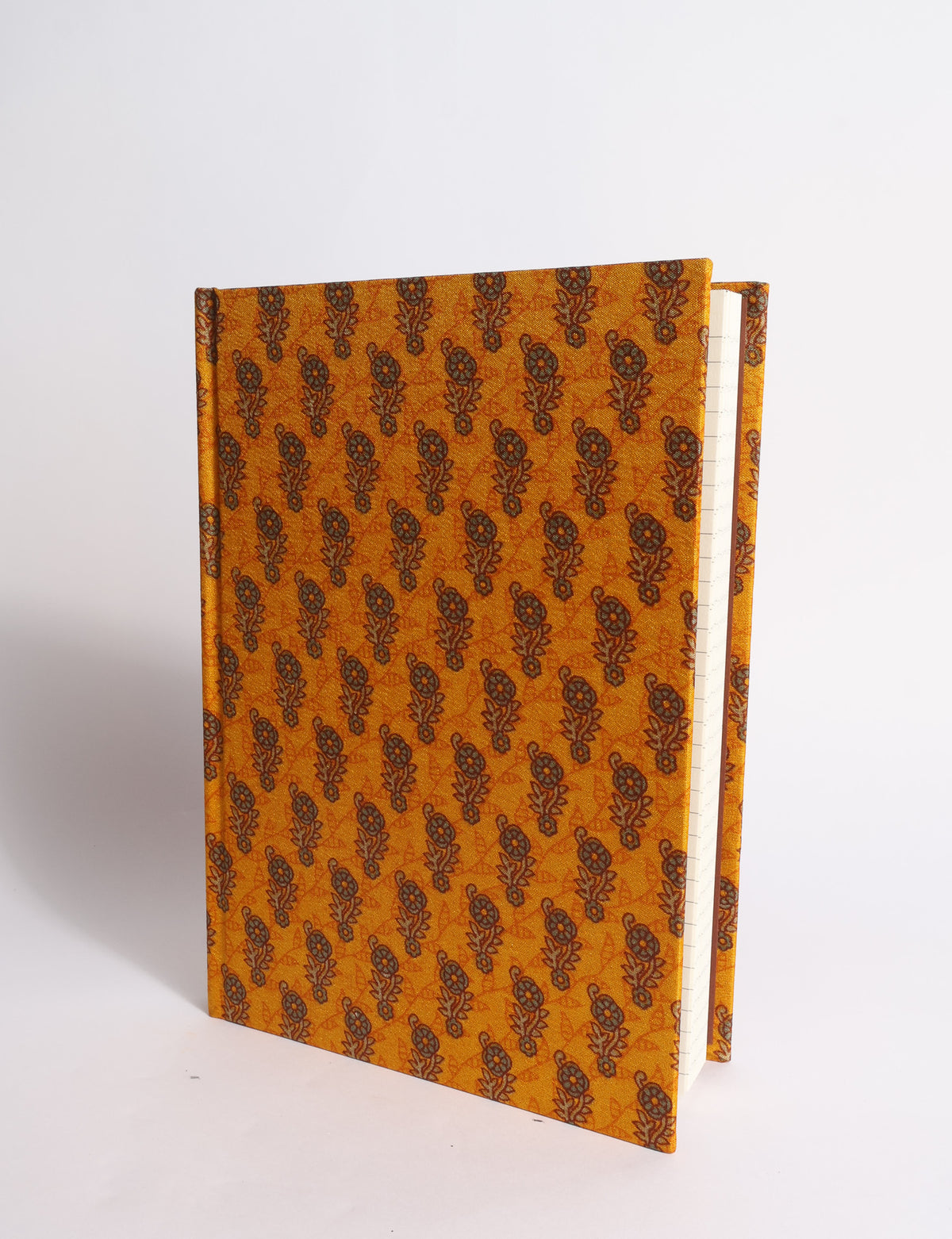 A5 hard cover notebook with dark blue cover featuring beige floral pattern, shown partially open with lined pages visible