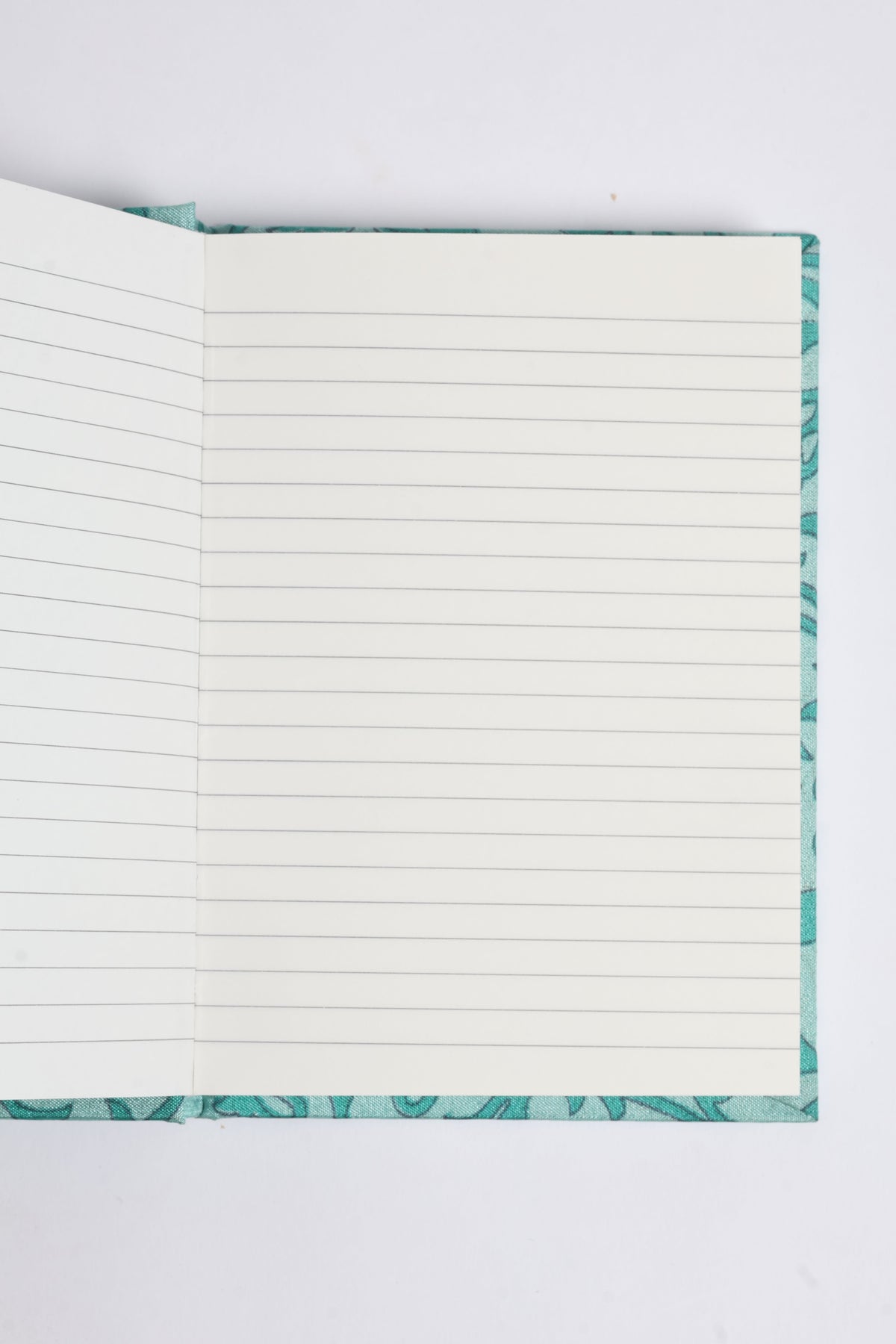 Open A6 hard cover notebook with turquoise pre-loved sari fabric cover and square-lined white pages visible