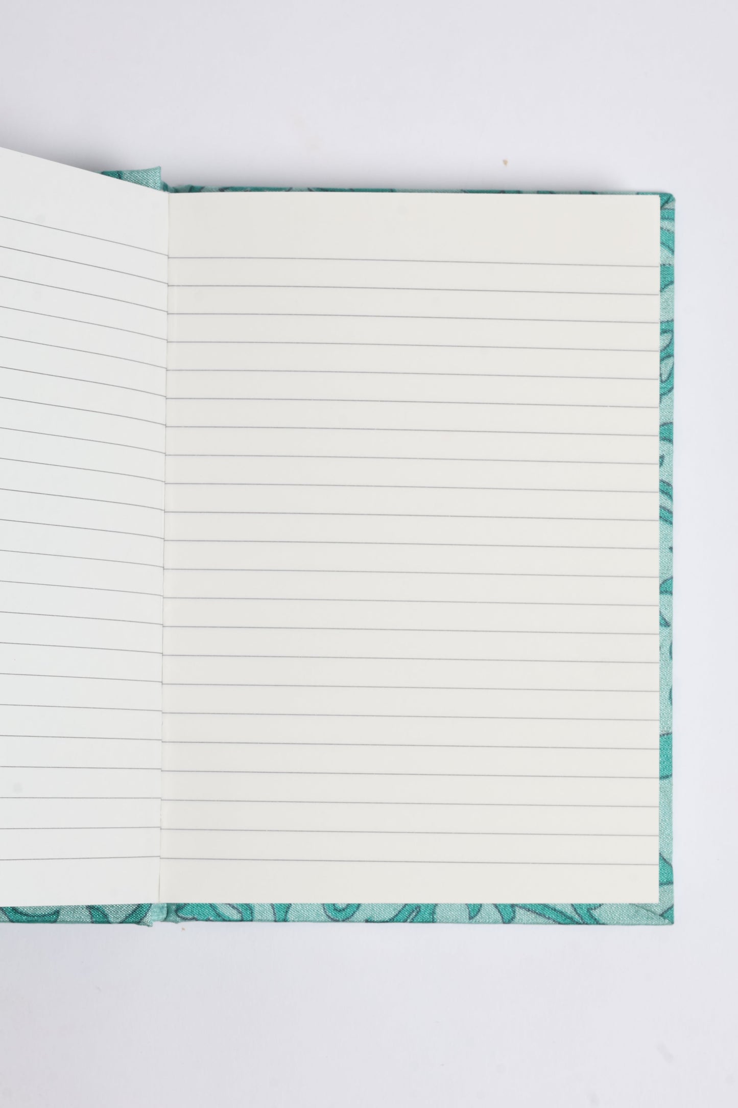 I was a Sari A6 Hard Cover Notebook in teal with lined pages and a textured cover design.