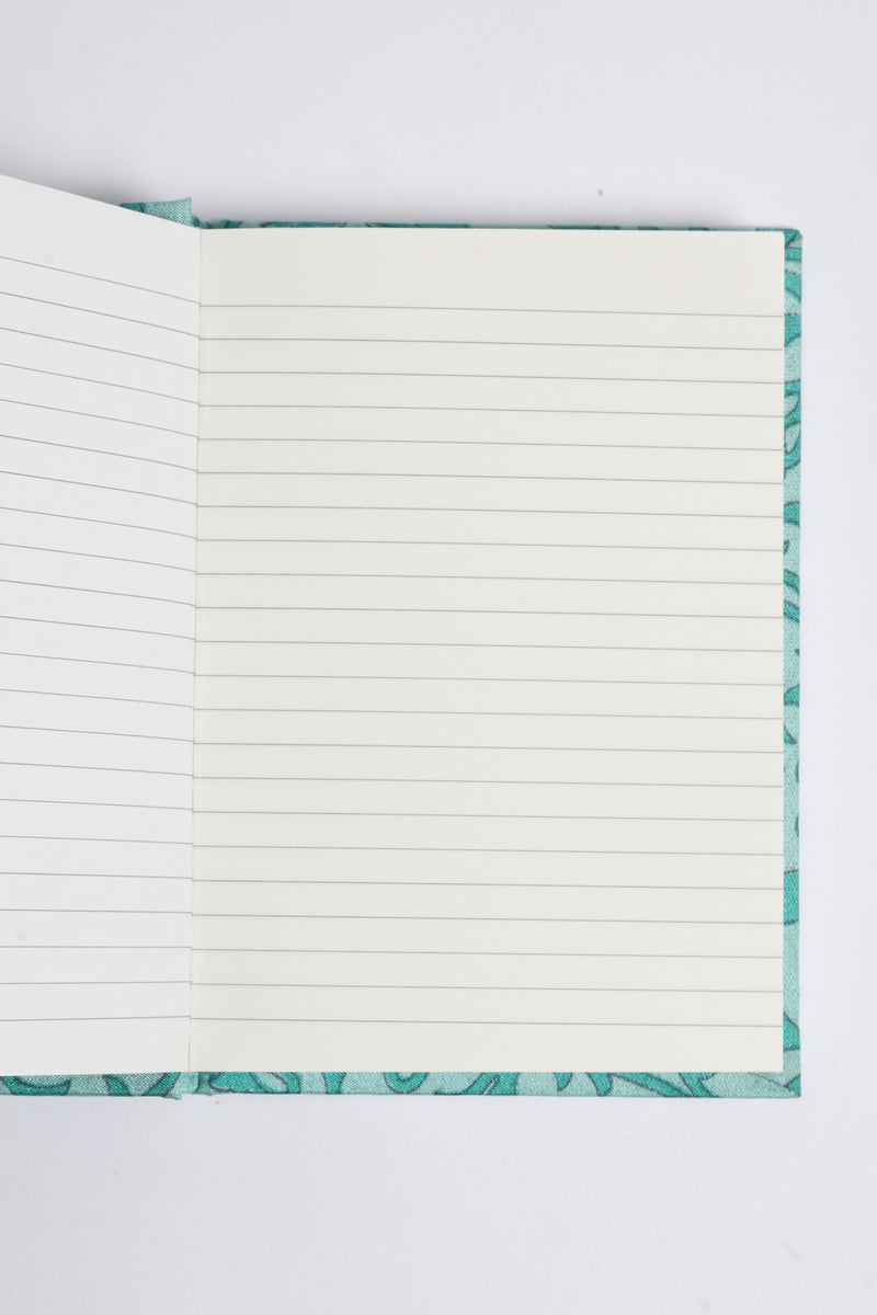 Open A6 hard cover notebook with lined pages and a turquoise pre-loved sari fabric cover visible at edges