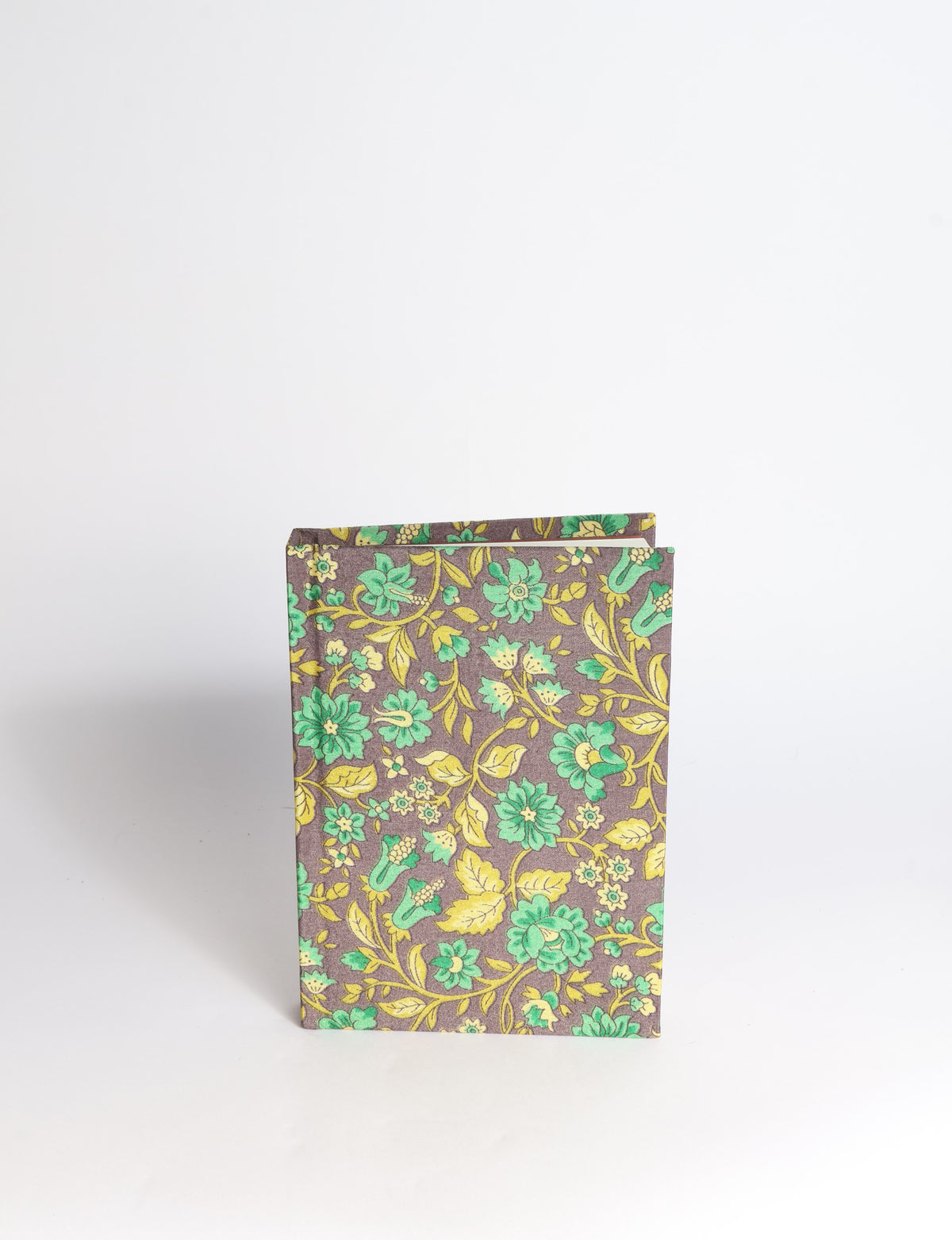 A6 hard cover notebook with teal pre-loved sari fabric cover featuring dark green floral vine pattern, standing upright