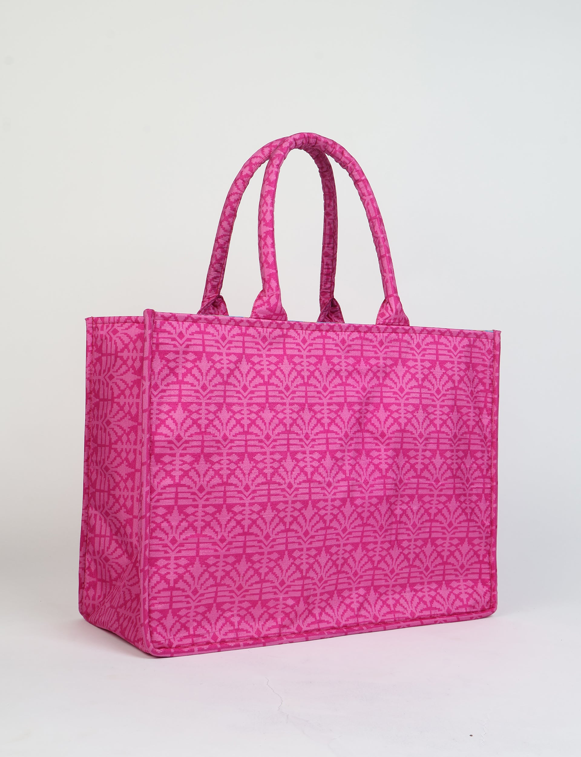 Pink tote bag with geometric leaf pattern, two padded handles, and rectangular shape, shown standing on white background