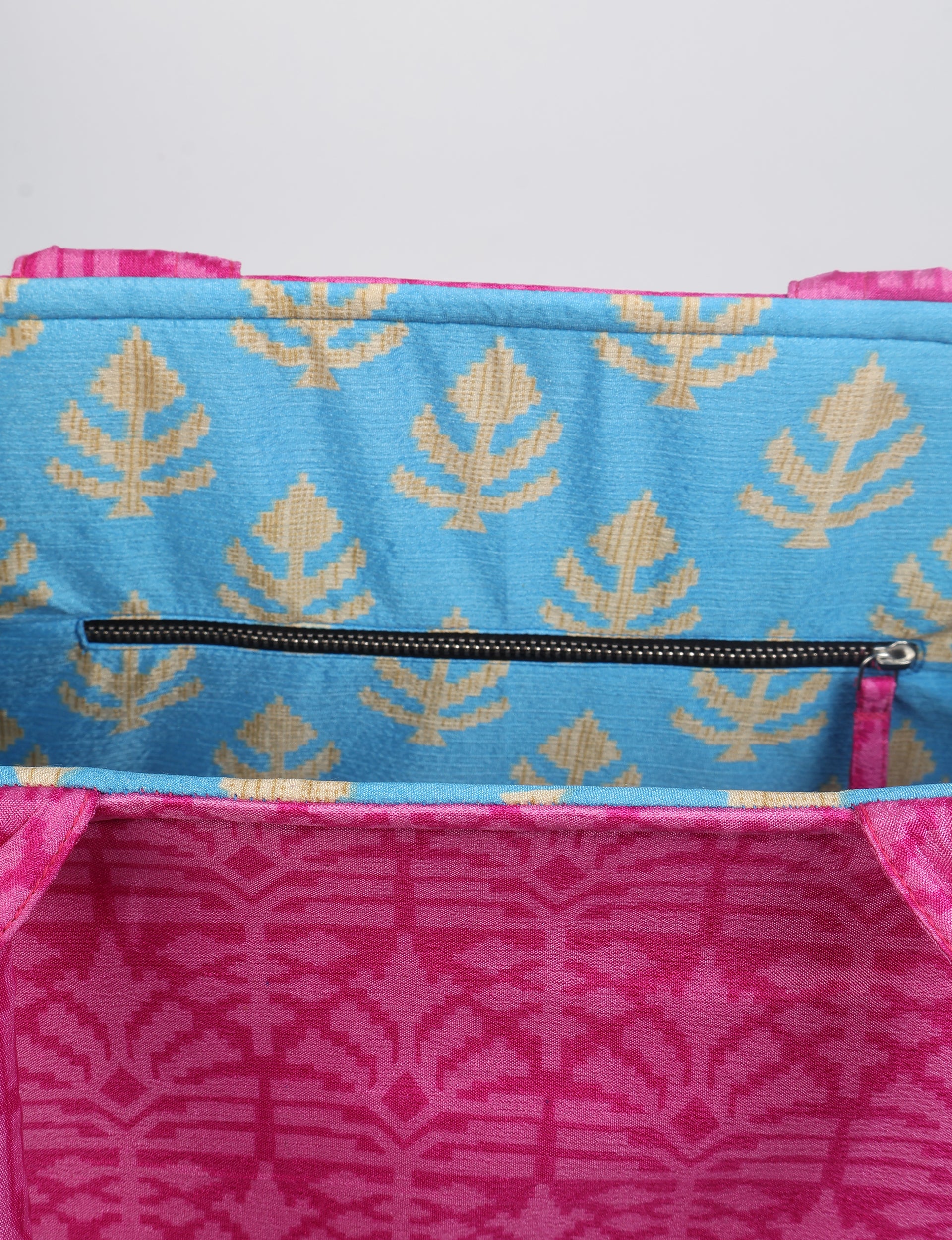 Pink fabric work tote bag with geometric pattern, blue interior lining with beige leaf motifs, and black zipper pocket