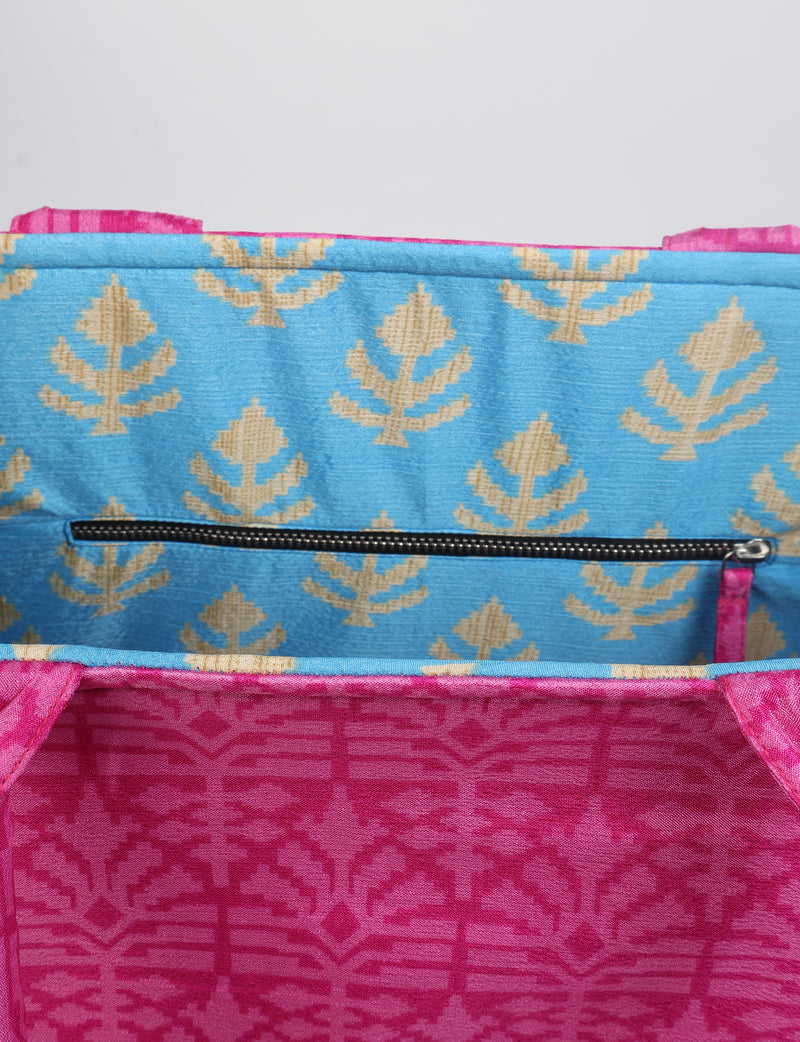 Pink fabric work tote bag with geometric pattern, blue interior lining with beige leaf motifs, and black zipper pocket