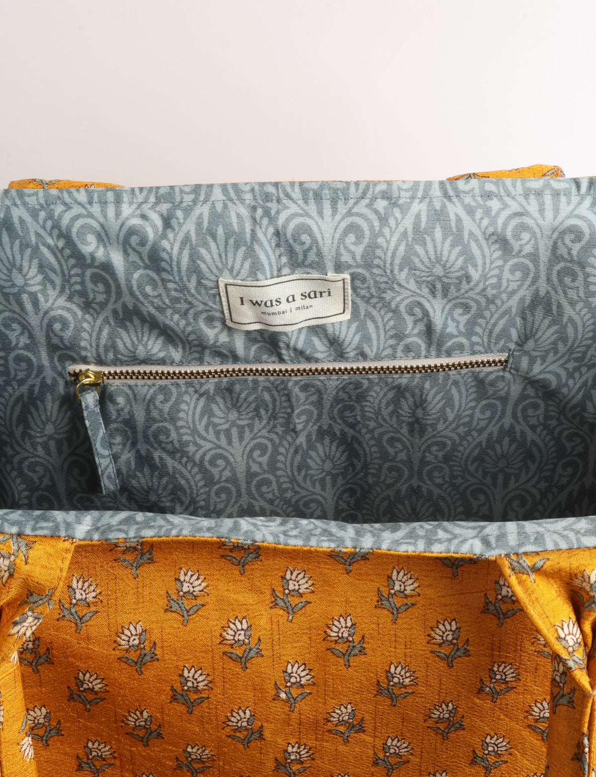 Grey floral fabric work tote bag with blue and beige flowers, teal interior lining with beige polka dots, and fabric handles