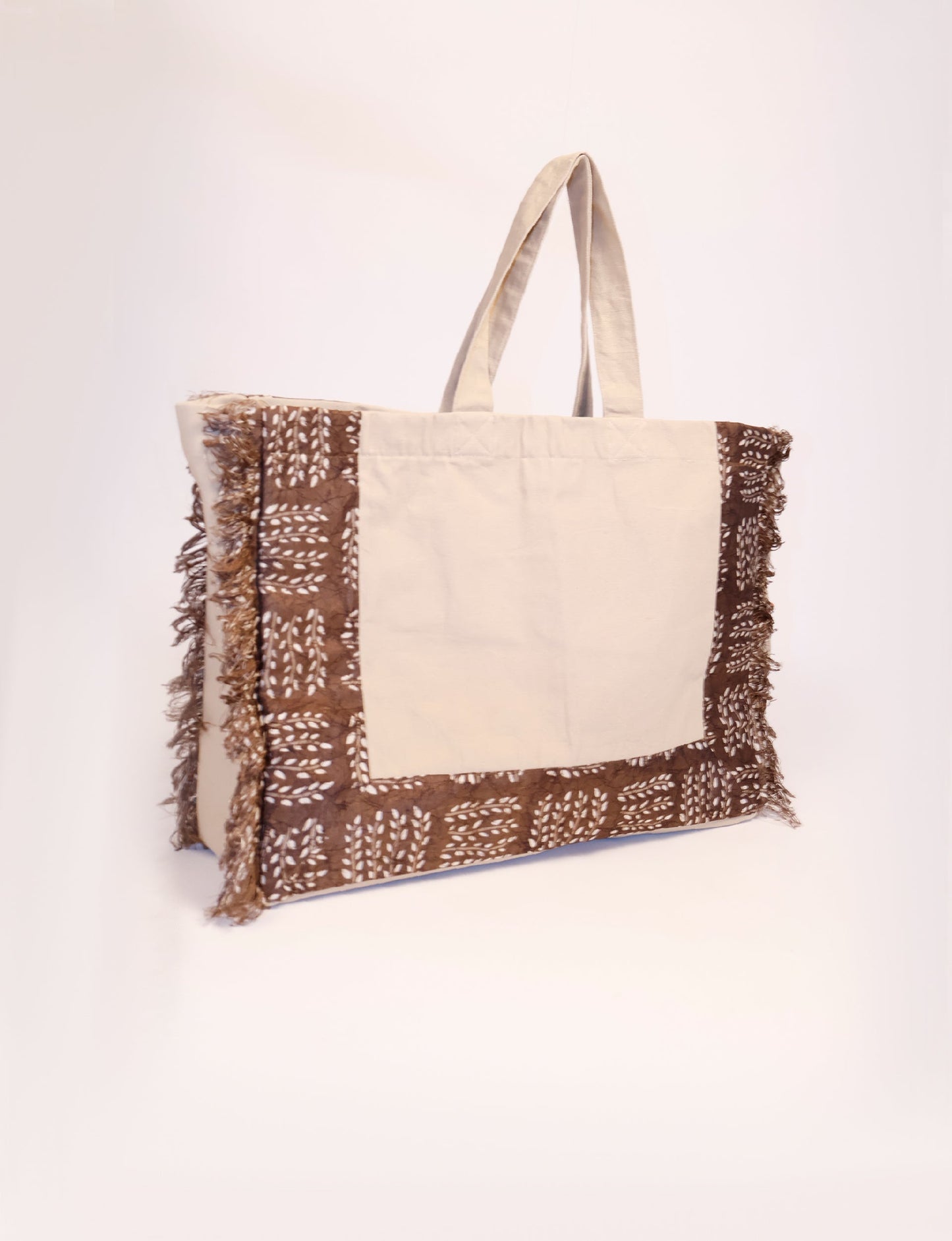 Lighten your eco-load with our FRINGE CARRY-ALL BAG. Soft canvas with a patchwork design, inside lining made of vibrant sari fabric, and beautifully soft sari-fringed edging. Crafted with 100% cotton canvas for a sustainable and stylish carry-all.