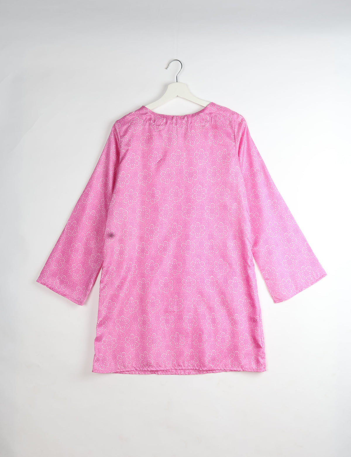 Pink long-sleeve dress with all-over white floral pattern, shown from back on white hanger against white background
