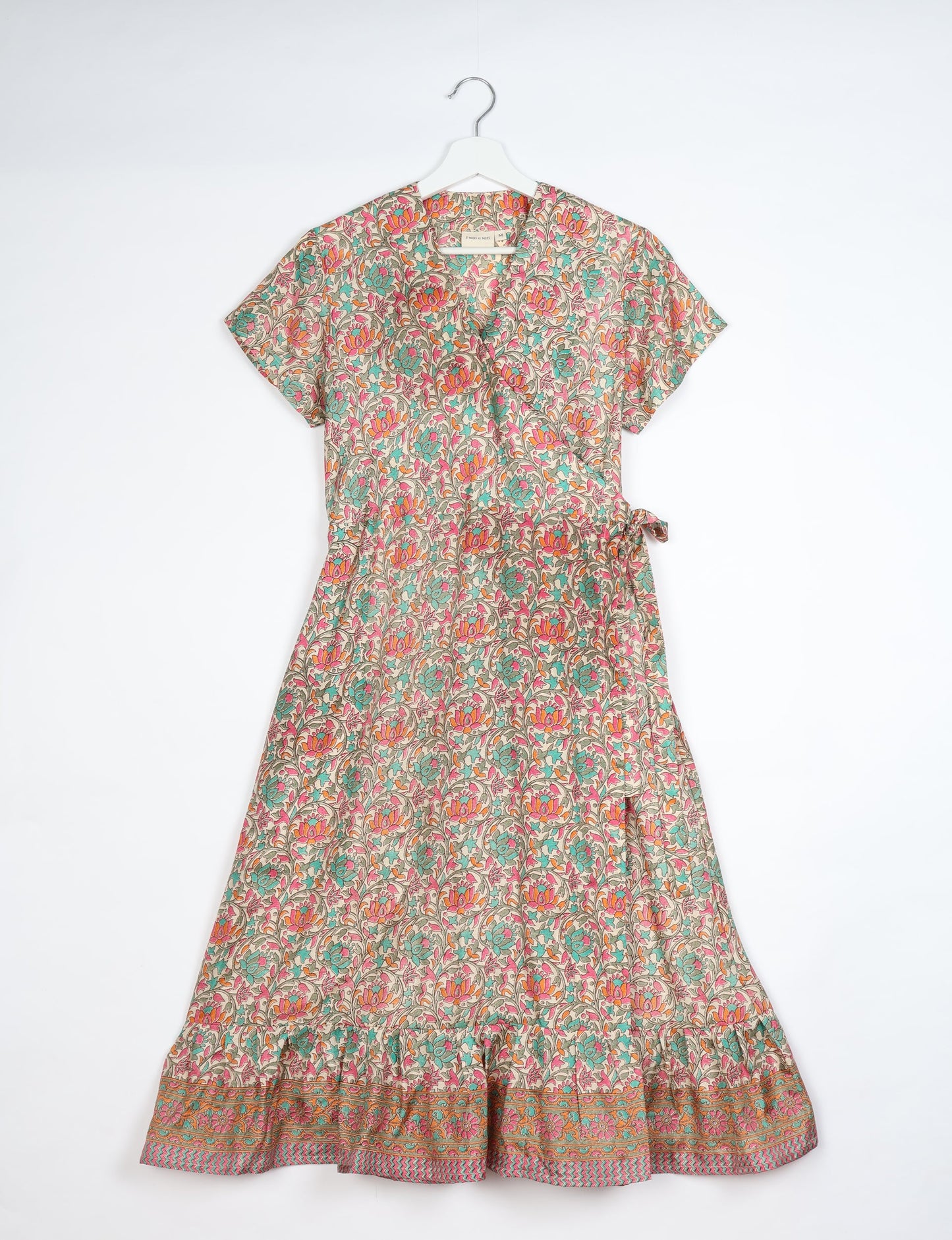 Embrace timeless elegance with our MIDI WRAP DRESS – a midi-length beauty featuring a v-neck, flattery from all angles, and a charming sari belt. Crafted from sustainable materials, this dress embodies ethical clothing and green fashion. Sophisticated with a frill tier at the hem and short cap sleeves, this dress is perfect for any occasion. Tie up the beautifully crafted sari belt on the side for a versatile, stylish, and eco-friendly look.