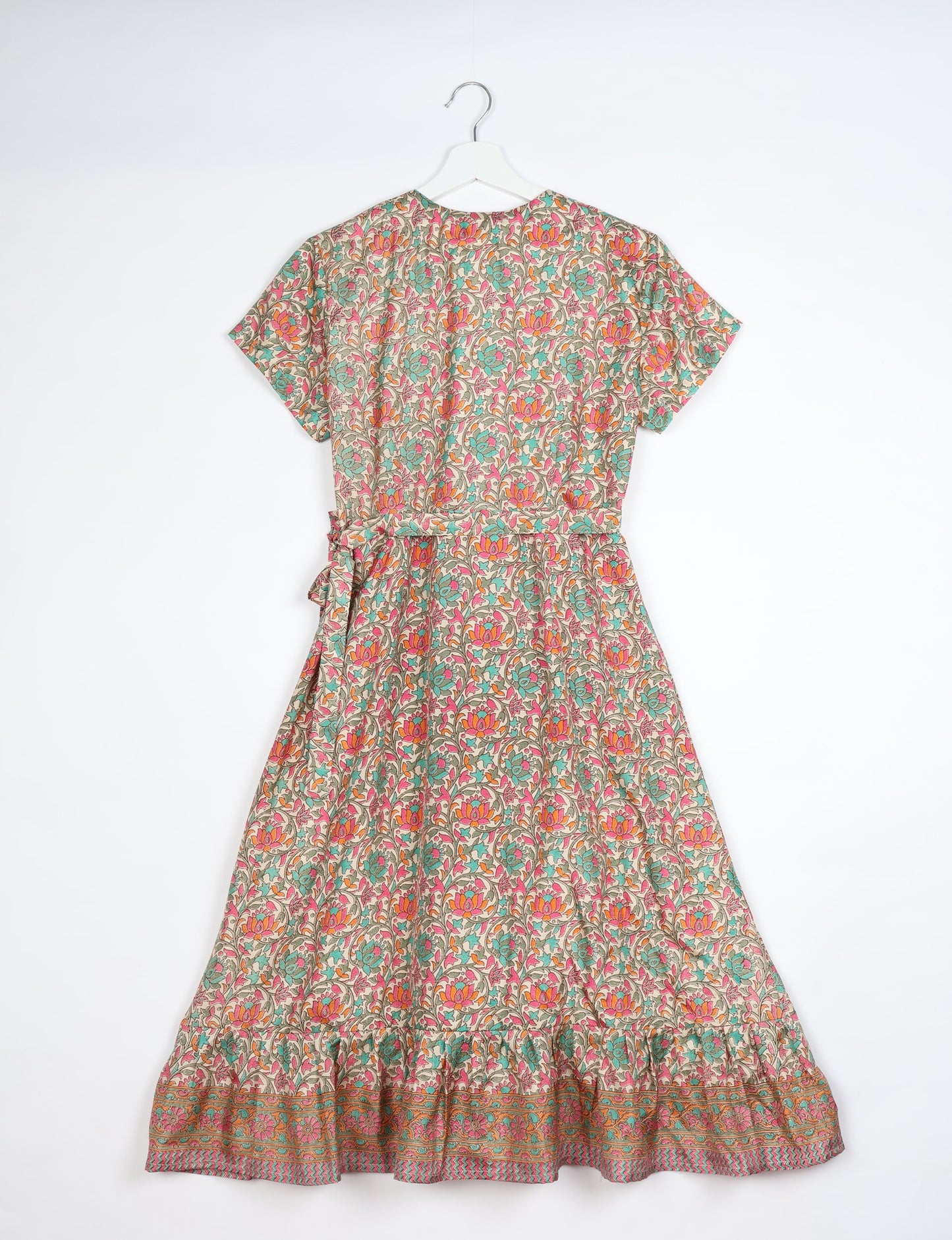 Embrace timeless elegance with our MIDI WRAP DRESS – a midi-length beauty featuring a v-neck, flattery from all angles, and a charming sari belt. Crafted from sustainable materials, this dress embodies ethical clothing and green fashion. Sophisticated with a frill tier at the hem and short cap sleeves, this dress is perfect for any occasion. Tie up the beautifully crafted sari belt on the side for a versatile, stylish, and eco-friendly look.