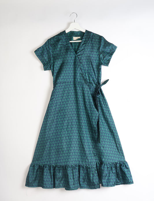 Embrace timeless elegance with our MIDI WRAP DRESS – a midi-length beauty featuring a v-neck, flattery from all angles, and a charming sari belt. Crafted from sustainable materials, this dress embodies ethical clothing and green fashion. Sophisticated with a frill tier at the hem and short cap sleeves, this dress is perfect for any occasion. Tie up the beautifully crafted sari belt on the side for a versatile, stylish, and eco-friendly look.