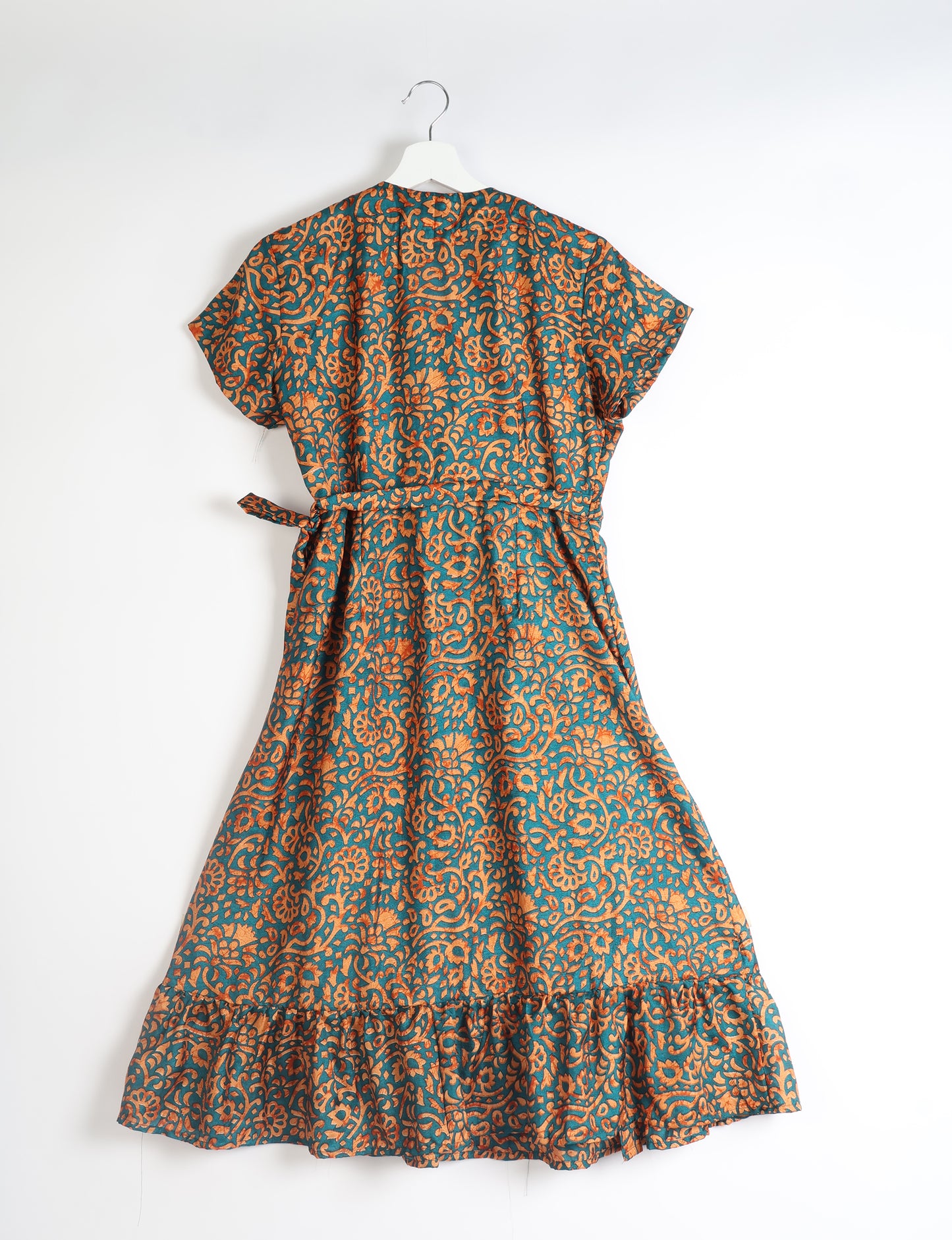 Embrace timeless elegance with our MIDI WRAP DRESS – a midi-length beauty featuring a v-neck, flattery from all angles, and a charming sari belt. Crafted from sustainable materials, this dress embodies ethical clothing and green fashion. Sophisticated with a frill tier at the hem and short cap sleeves, this dress is perfect for any occasion. Tie up the beautifully crafted sari belt on the side for a versatile, stylish, and eco-friendly look.