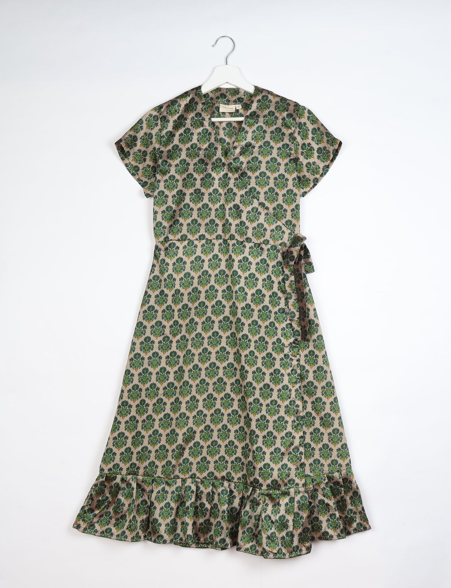 Embrace timeless elegance with our MIDI WRAP DRESS – a midi-length beauty featuring a v-neck, flattery from all angles, and a charming sari belt. Crafted from sustainable materials, this dress embodies ethical clothing and green fashion. Sophisticated with a frill tier at the hem and short cap sleeves, this dress is perfect for any occasion. Tie up the beautifully crafted sari belt on the side for a versatile, stylish, and eco-friendly look.