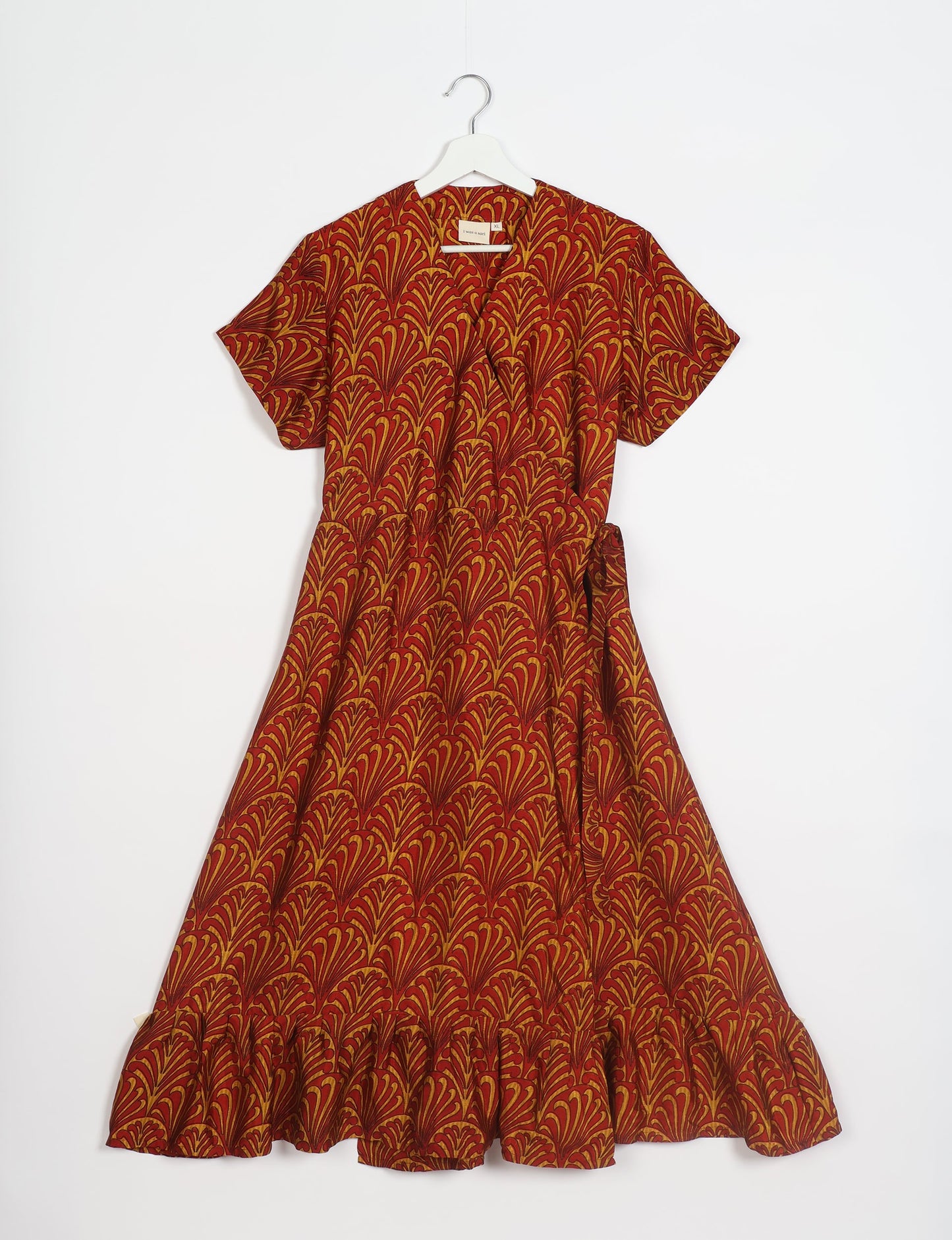 Embrace timeless elegance with our MIDI WRAP DRESS – a midi-length beauty featuring a v-neck, flattery from all angles, and a charming sari belt. Crafted from sustainable materials, this dress embodies ethical clothing and green fashion. Sophisticated with a frill tier at the hem and short cap sleeves, this dress is perfect for any occasion. Tie up the beautifully crafted sari belt on the side for a versatile, stylish, and eco-friendly look.