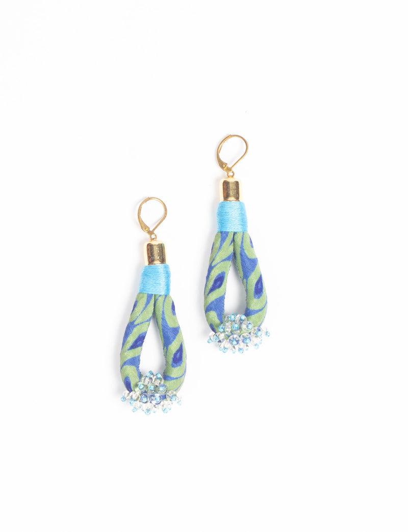 Blue and green fabric loop drop earrings with gold hooks and clustered blue and clear beads at the bottom, flat lay view