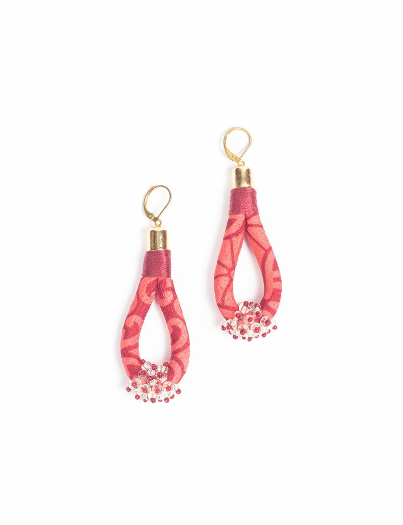 Pink abstract patterned fabric drop earrings with gold-tone hooks and clear and red bead clusters at the bottom