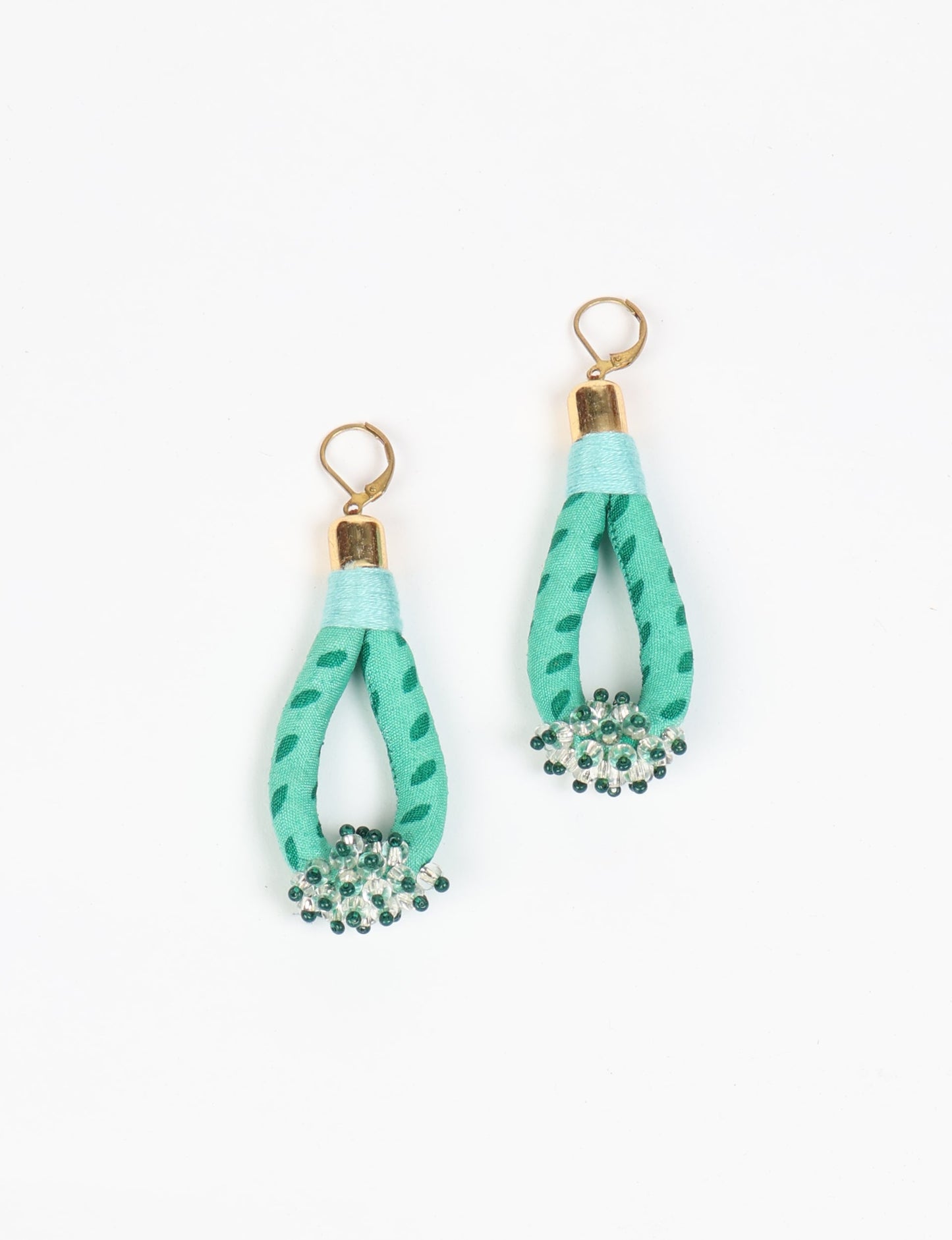 Discover the charm of Beaded Drop Earrings, meticulously crafted by Indian artisans. Recycled cotton rope, sari fabric, and surplus glass beads create an eco-friendly masterpiece. Hypoallergenic metal hooks ensure both style and comfort.