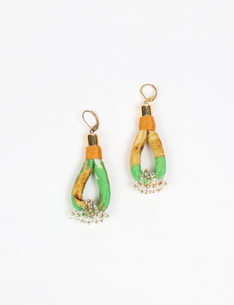 Green and yellow fabric loop drop earrings with gold-tone hooks and clear bead clusters at the bottom, flat lay view
