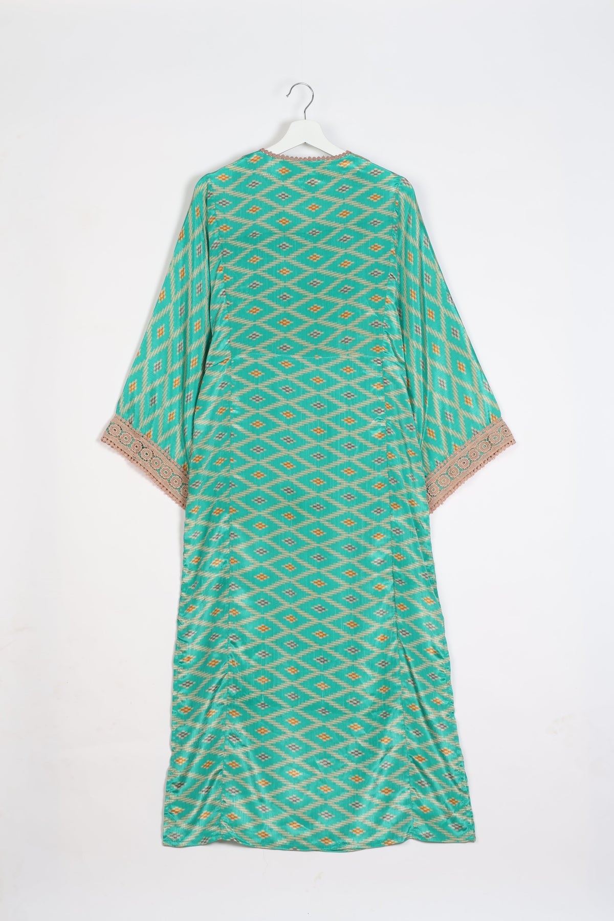 Green maxi kaftan with geometric diamond pattern, beige lace trim on sleeves, shown from back on white hanger