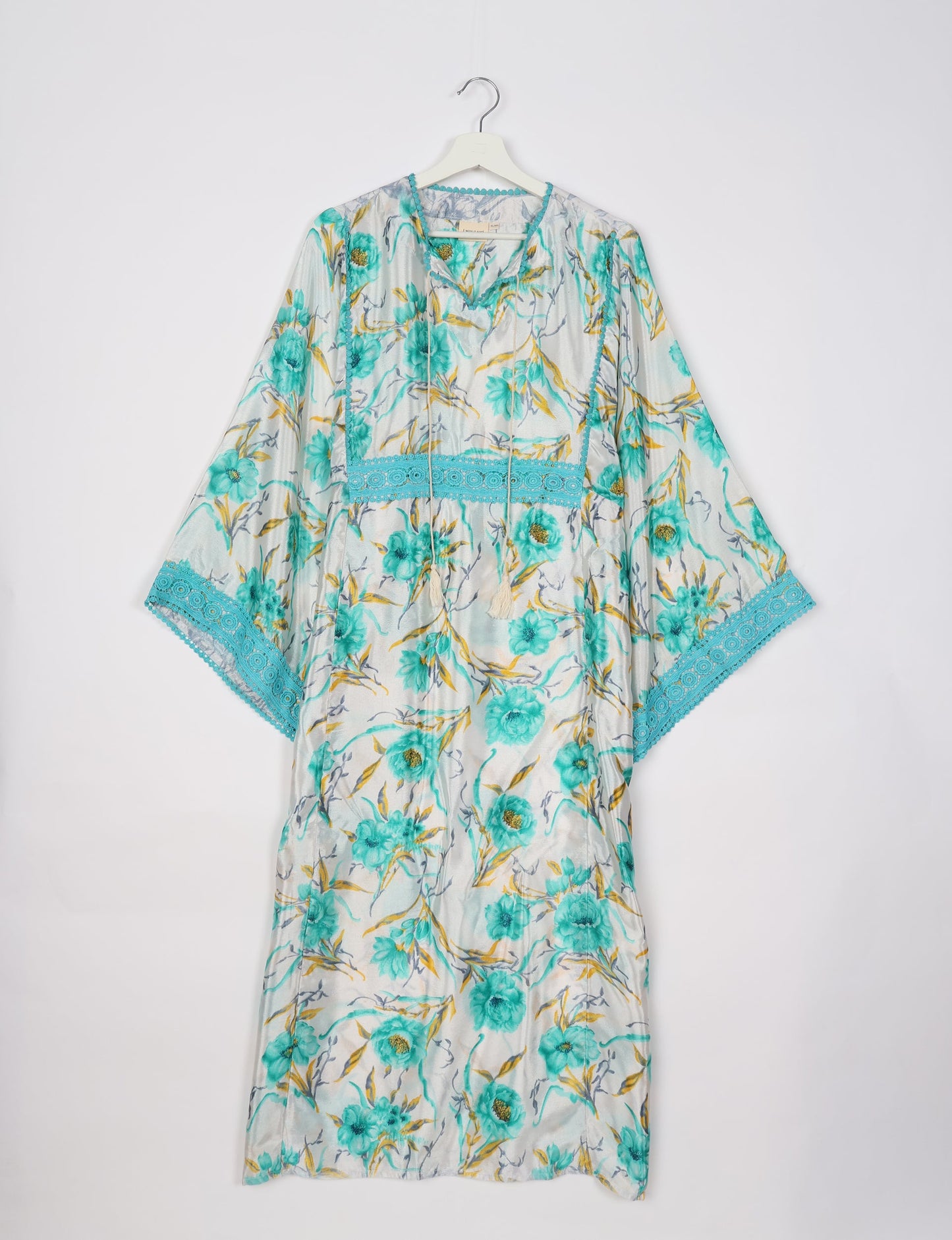 Maxi Kaftan with cotton lace on sleeves and midriff, featuring a tie-up neckline with tassels. Ankle-length, eco-friendly fashion made from recycled materials, offering sustainable women’s clothing for a chic, earth-friendly wardrobe.