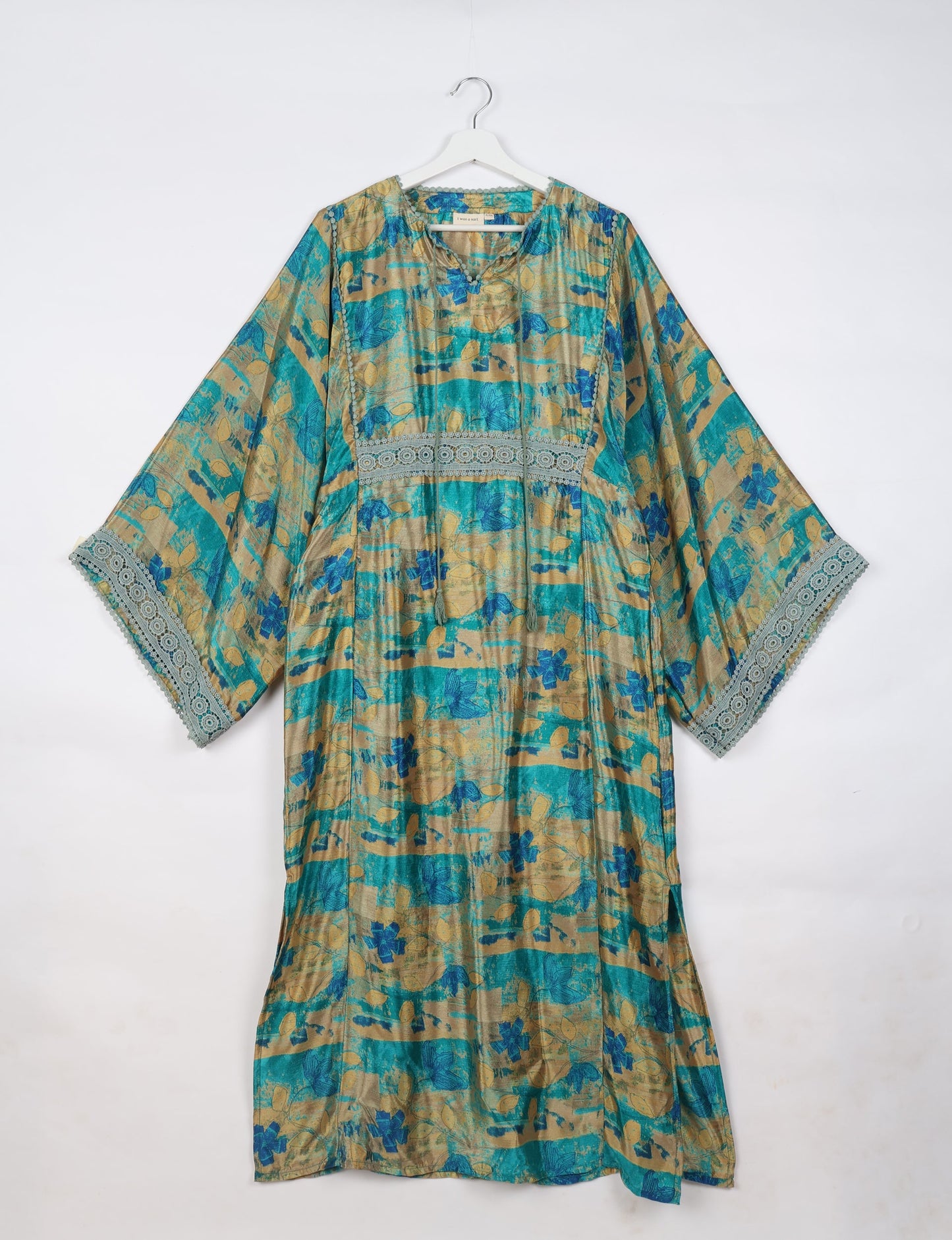 Maxi Kaftan with cotton lace on sleeves and midriff, featuring a tie-up neckline with tassels. Ankle-length, eco-friendly fashion made from recycled materials, offering sustainable women’s clothing for a chic, earth-friendly wardrobe.