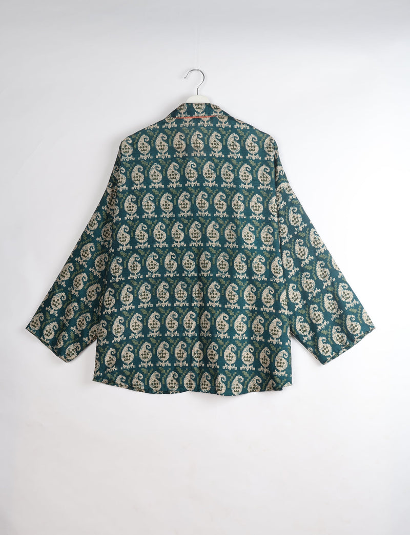 Oversized green shirt with beige paisley pattern, long sleeves, and spread collar, shown from back on hanger