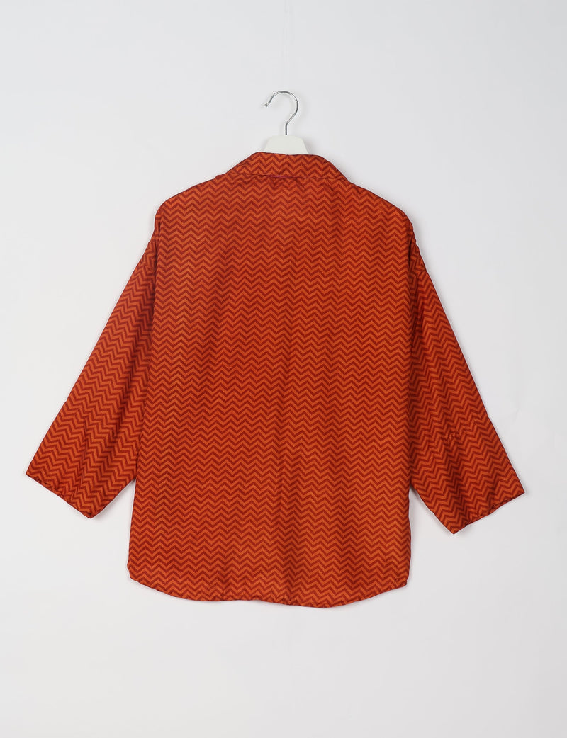 Red oversized shirt with dark red chevron geometric pattern, shown from back on white hanger against white background