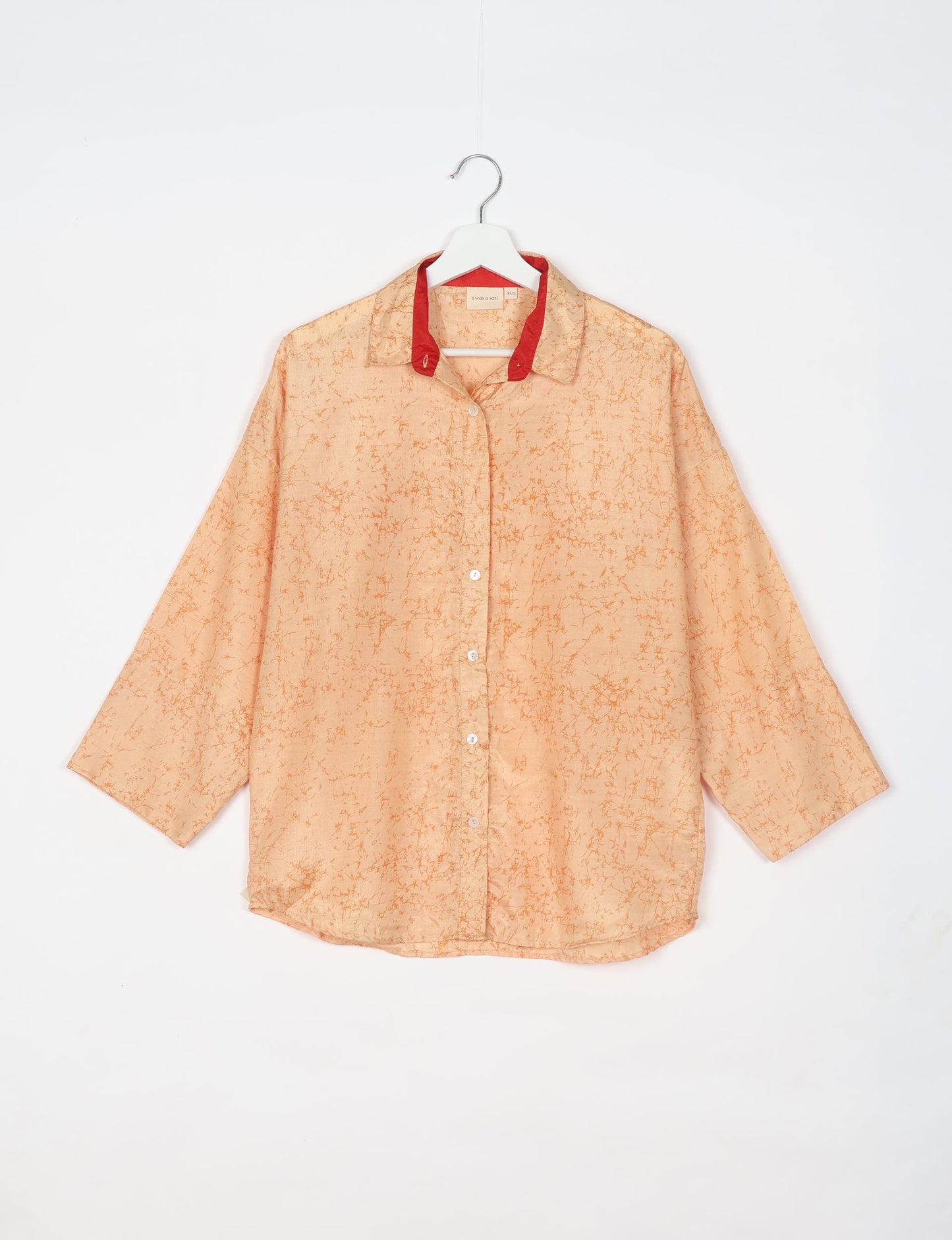 Experience chic comfort with our OVERSIZED SHIRT – a one-of-a-kind piece crafted from sari waste by talented Indian female artisans. With 3/4 length sleeves, a regular shirt collar, and a contrasting inner collar band, this shirt is perfect for work or casual hangouts. Versatile and stylish, it pairs effortlessly over a shift dress, jumpsuit, or with pants.
