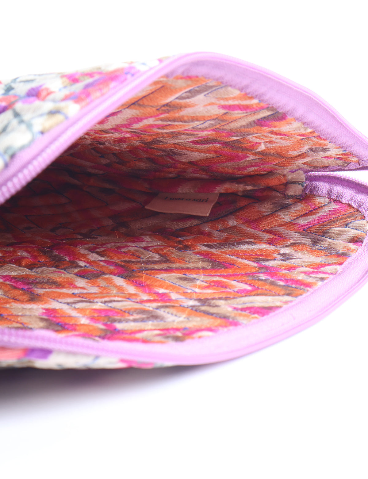 Quilted laptop sleeve with purple paisley exterior, red patterned interior, and light blue zipper, partially open showing label