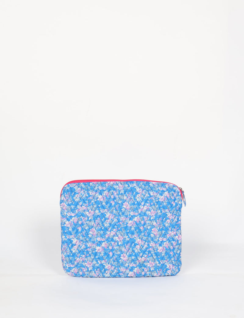 Quilted laptop sleeve with blue floral pattern, pink zipper, and diagonal stitching, shown front view on white background