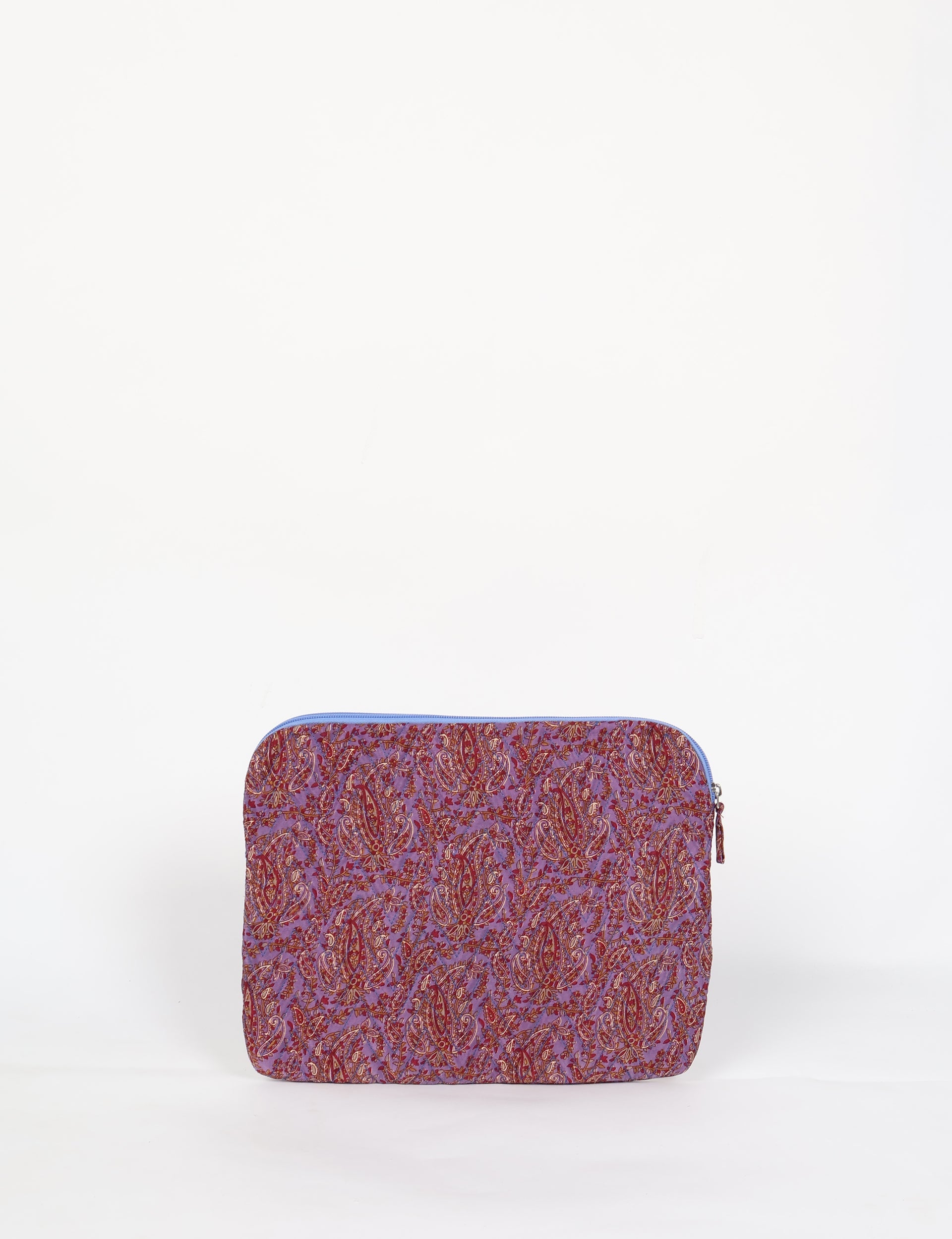 Quilted laptop sleeve with purple paisley pattern, blue zipper, and rounded corners, shown flat on white background