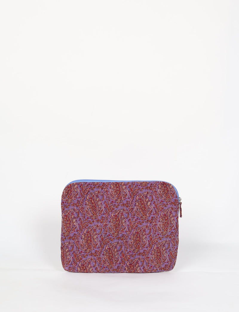 Quilted laptop sleeve with purple paisley pattern, blue zipper, and rounded corners, shown flat on white background