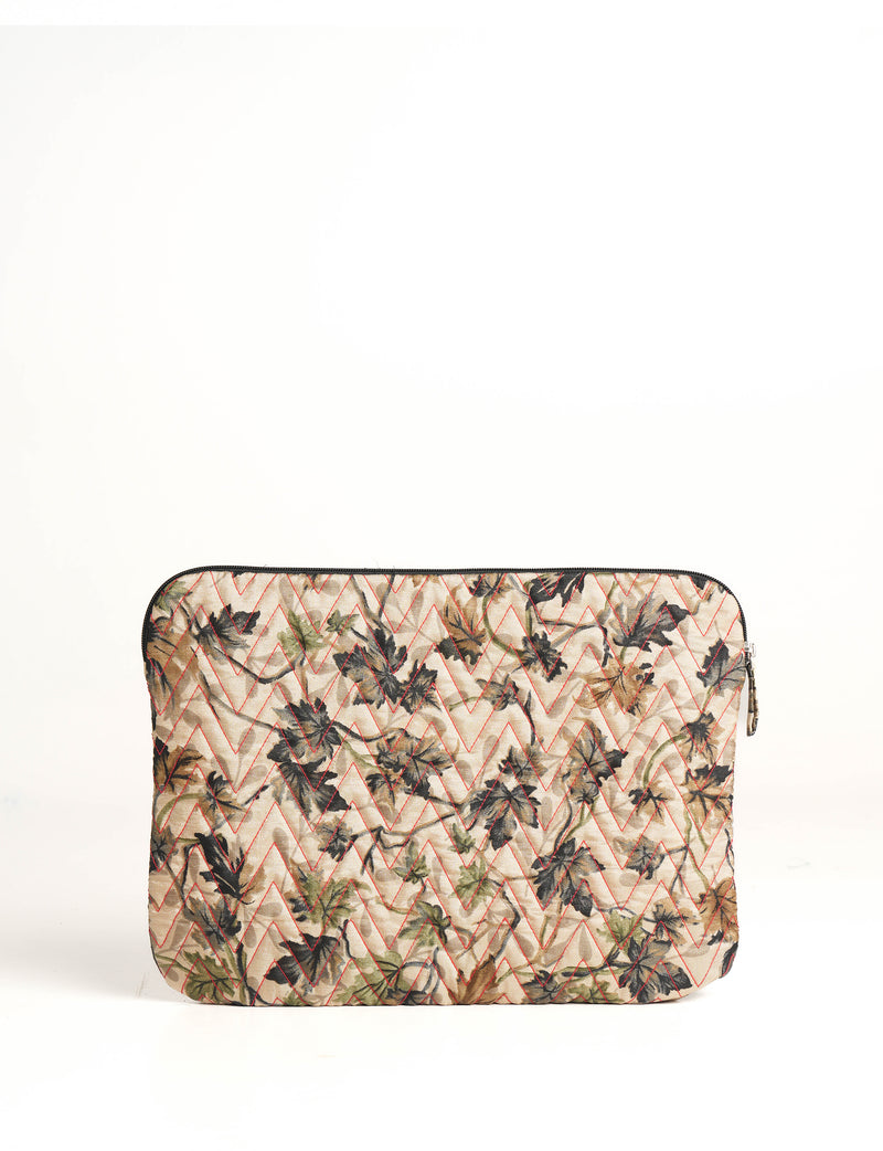 Quilted laptop sleeve with beige floral pattern and red zigzag stitching, front view, zipper closure on top edge