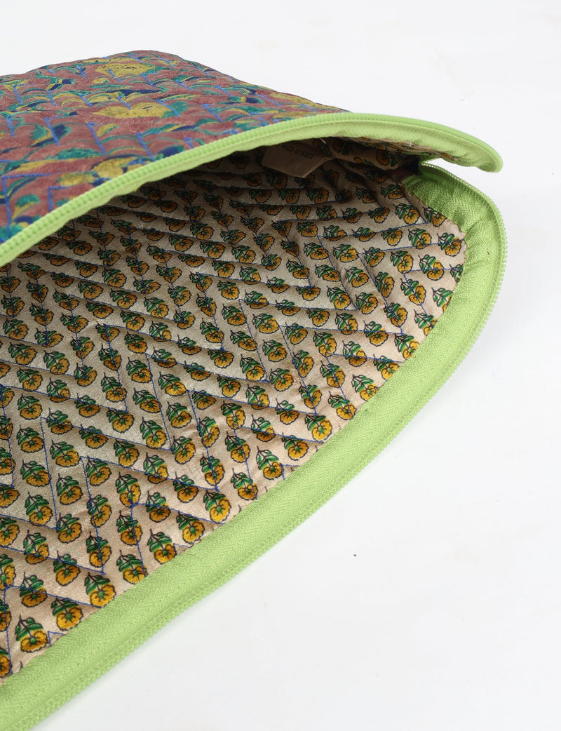 Quilted laptop sleeve with brown floral exterior, green zipper trim, and beige interior with small yellow flower print