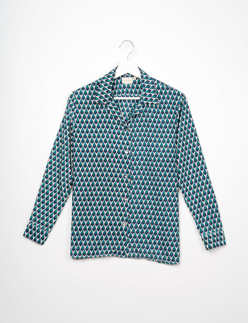 Green and blue leaf patterned long-sleeve resort shirt with collar and buttons, hanging on white hanger against white background