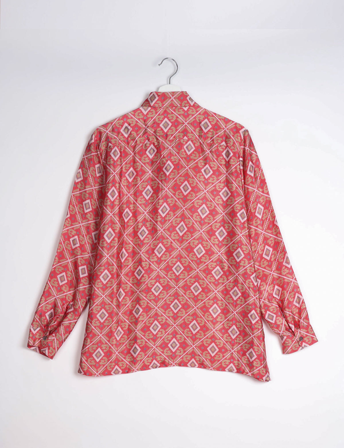 Pink geometric patterned long-sleeve resort shirt hanging on white hanger, back view with buttoned cuffs visible