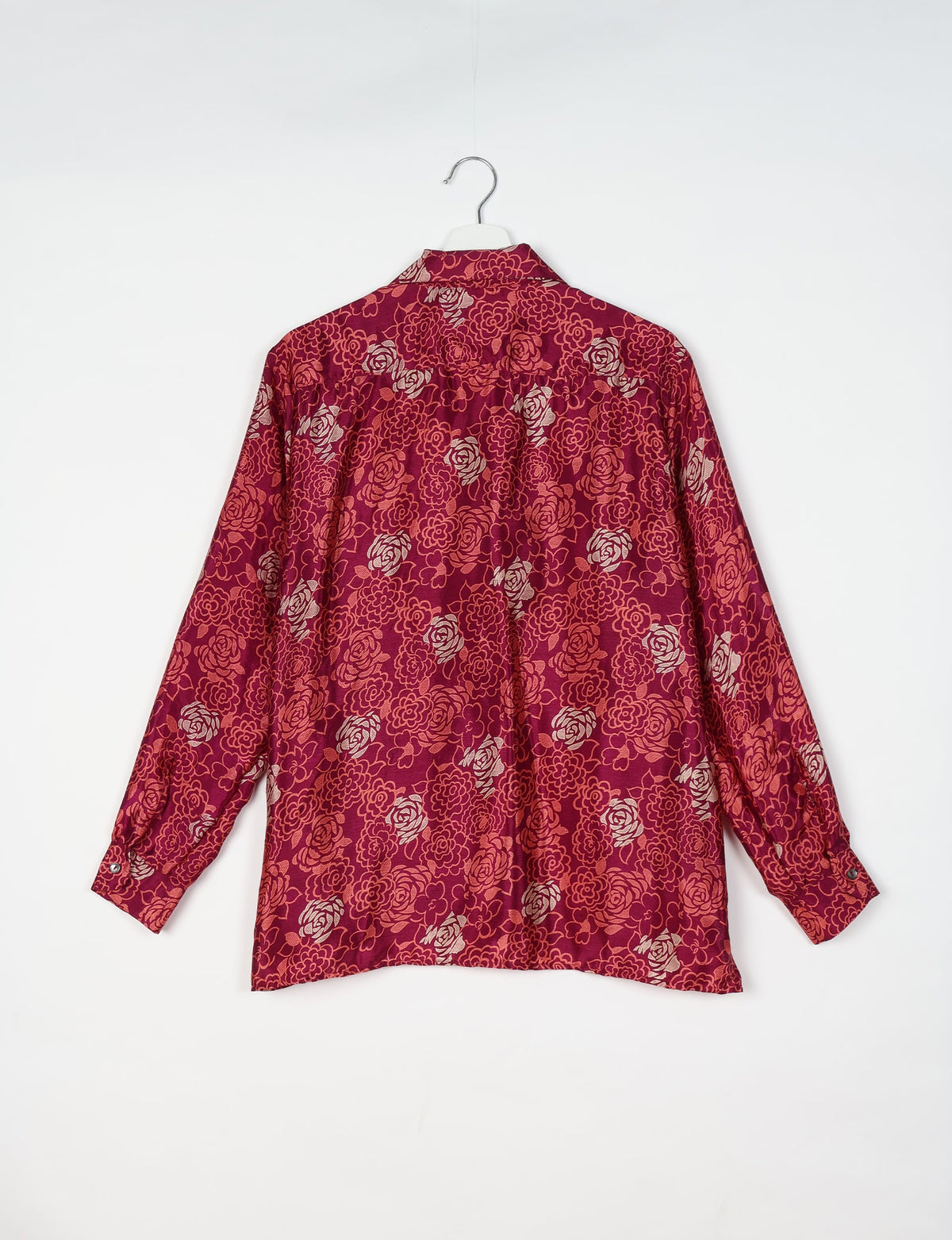Long-sleeve pink floral resort shirt with buttoned cuffs, shown from back on white hanger against white background