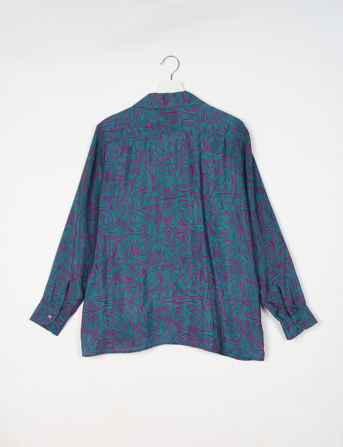 Blue resort shirt with abstract purple swirl pattern, long sleeves, buttoned cuffs, shown from back on hanger