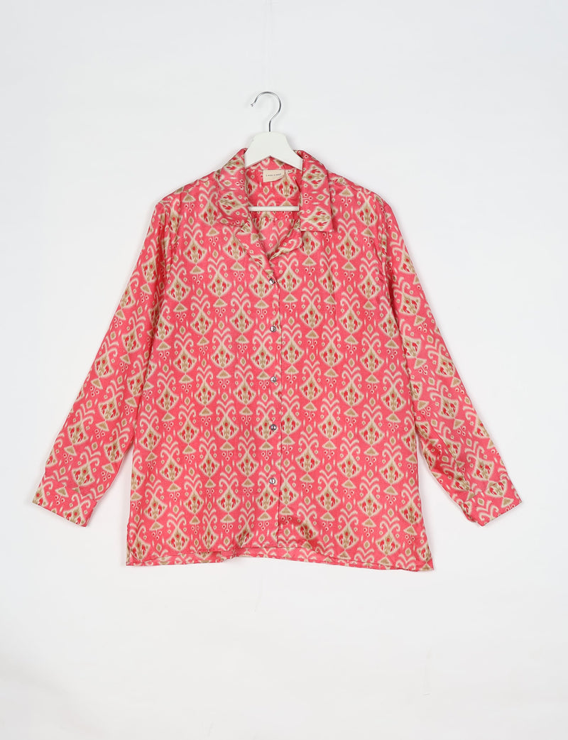 Pink long-sleeve resort shirt with Indian ethnic pattern, button front, and notched collar, hanging on white hanger