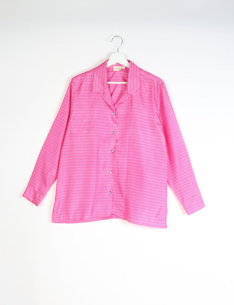 Long-sleeve red tropical resort shirt with small geometric pattern, button front, and notched collar, hanging on white hanger