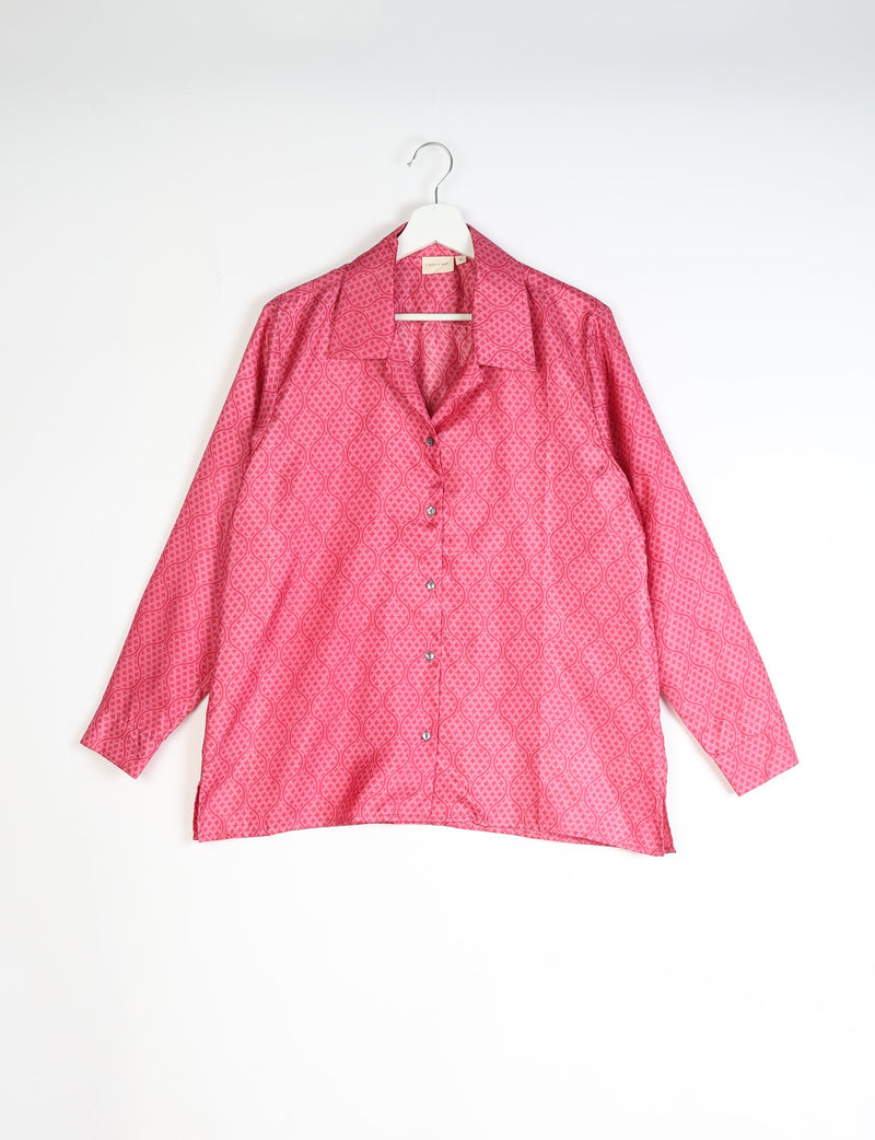 Red tropical patterned long-sleeve resort shirt with collar and buttons, hanging on white hanger against white background